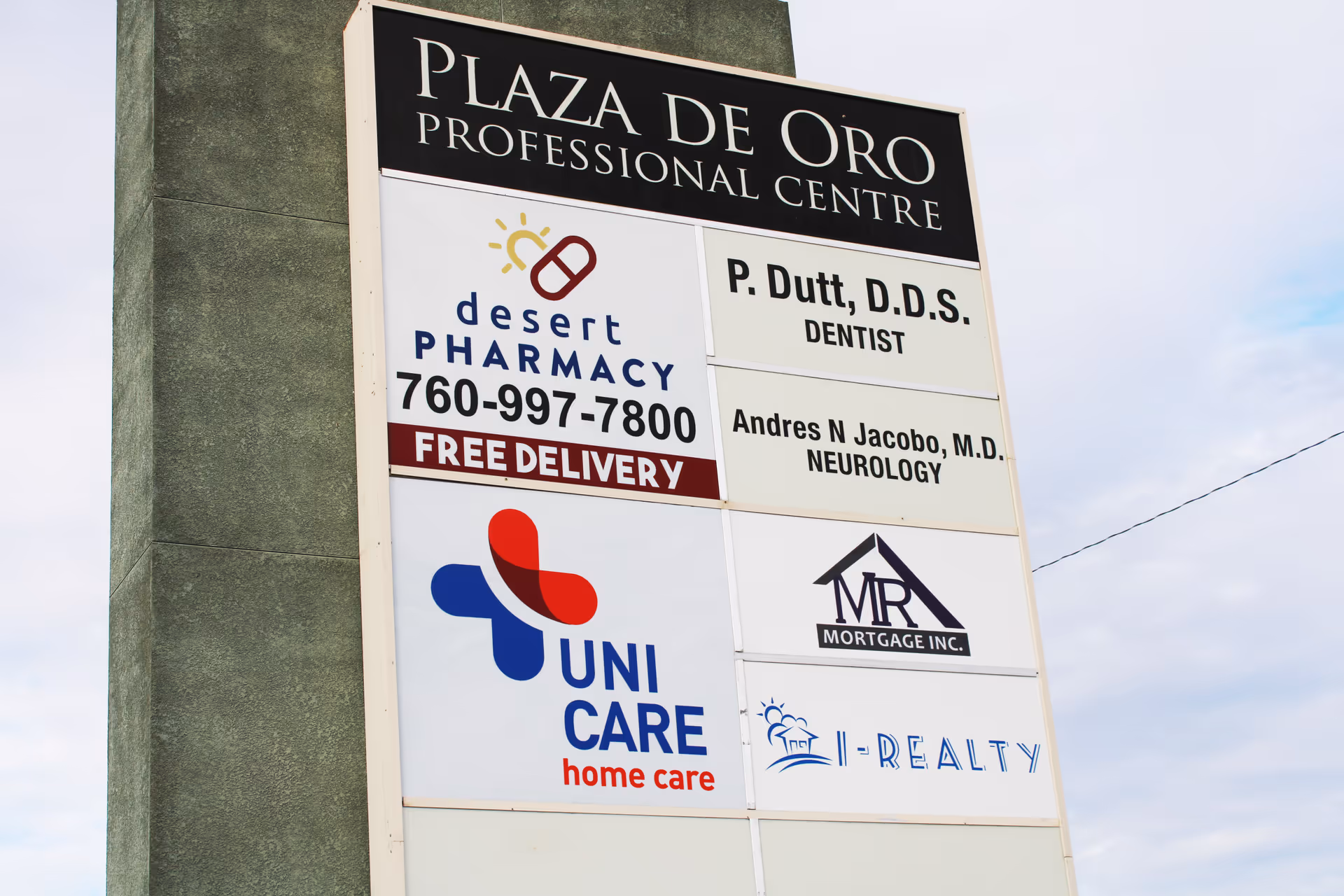 Outdoor signboard on building displaying Uni Care Home Care logo along with other ads.