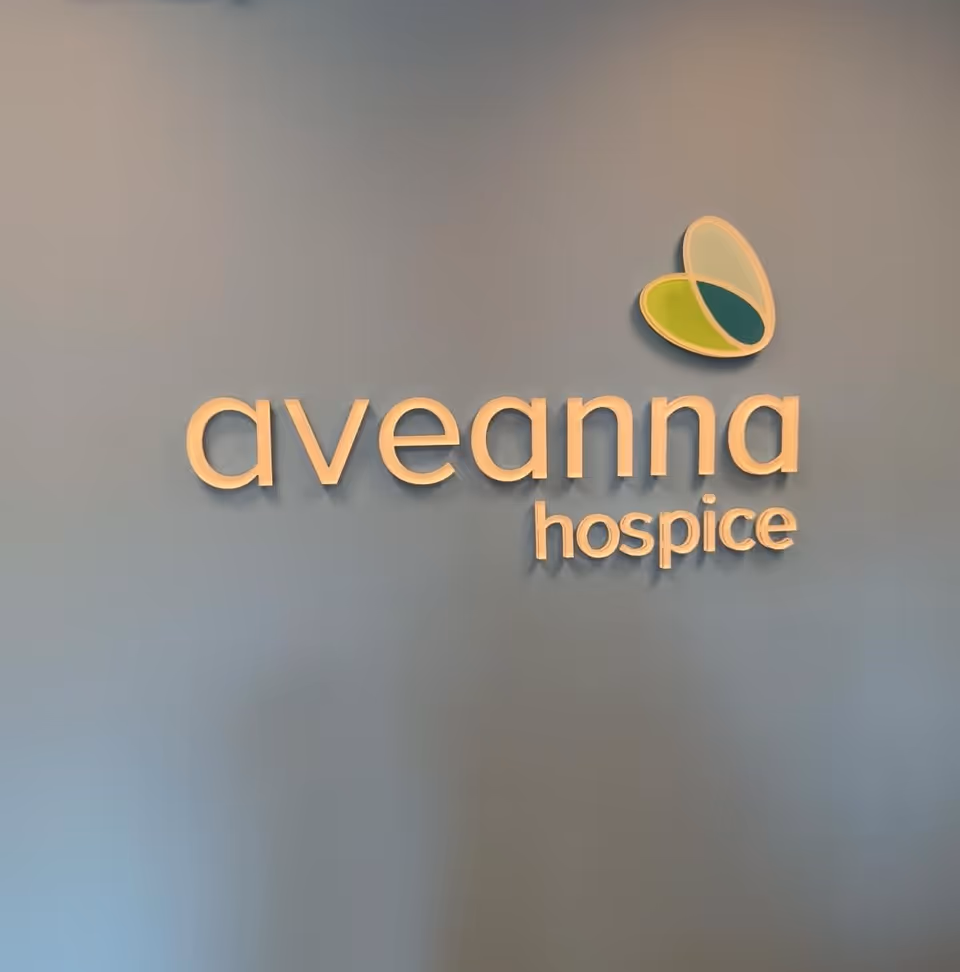 Blue interior wall featuring the Aveanna Hospice logo and butterfly emblem.