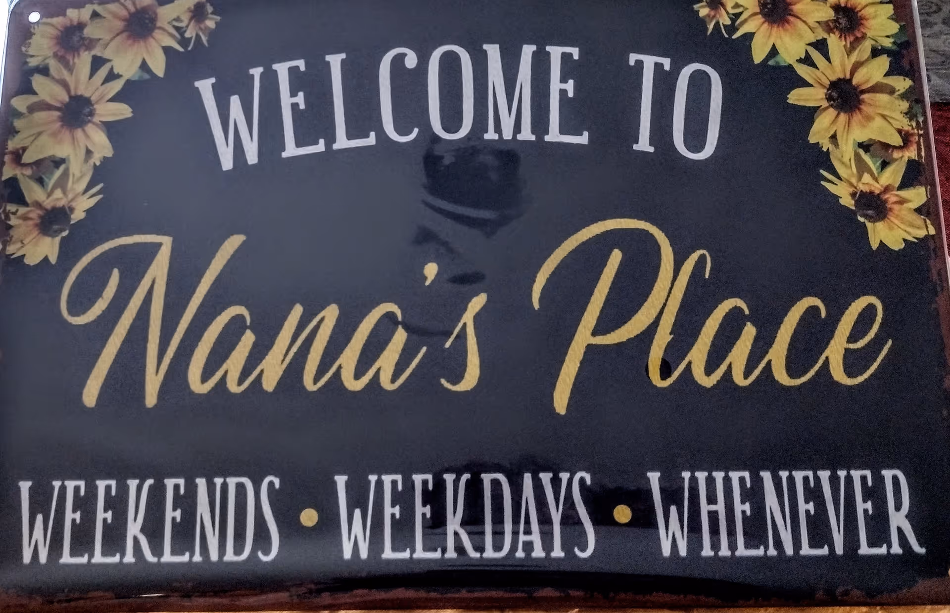 Sign reads Welcome to Nana's Place with sunflowers around the edges.