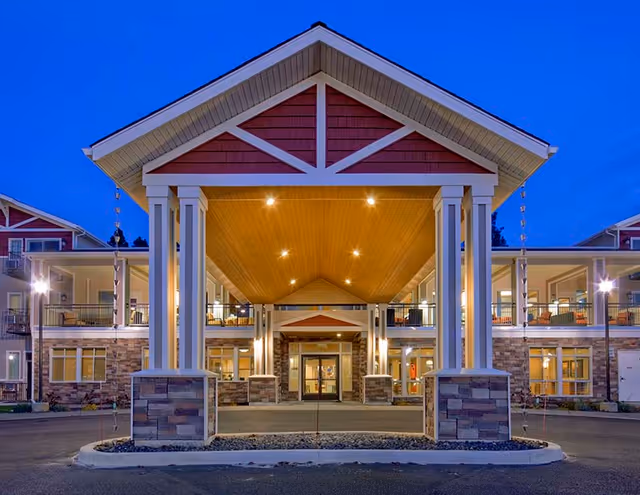Front entrance of Affinity at South Hill, a lit portico with tall columns and stone accents.