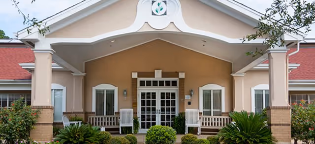 Front entrance of Brookdale Henderson senior living facility with arches and benches.