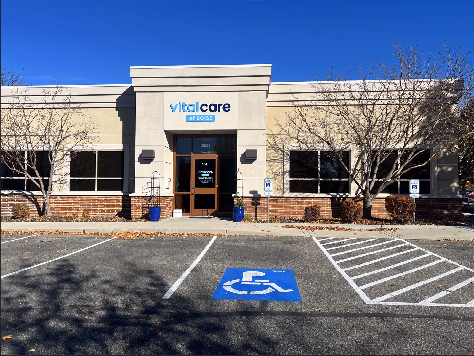 Front view of Vital Care building with entrance sign and accessible parking spaces.