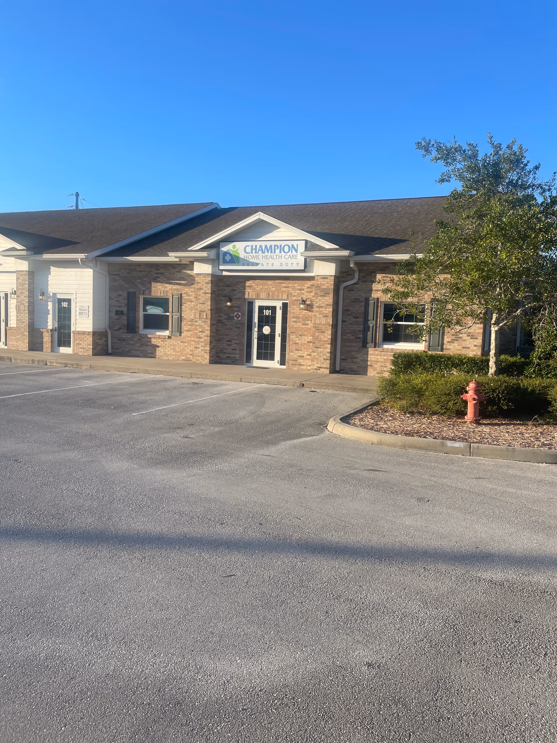 Front view of Champion Home Health Care building with brick exterior and sign.