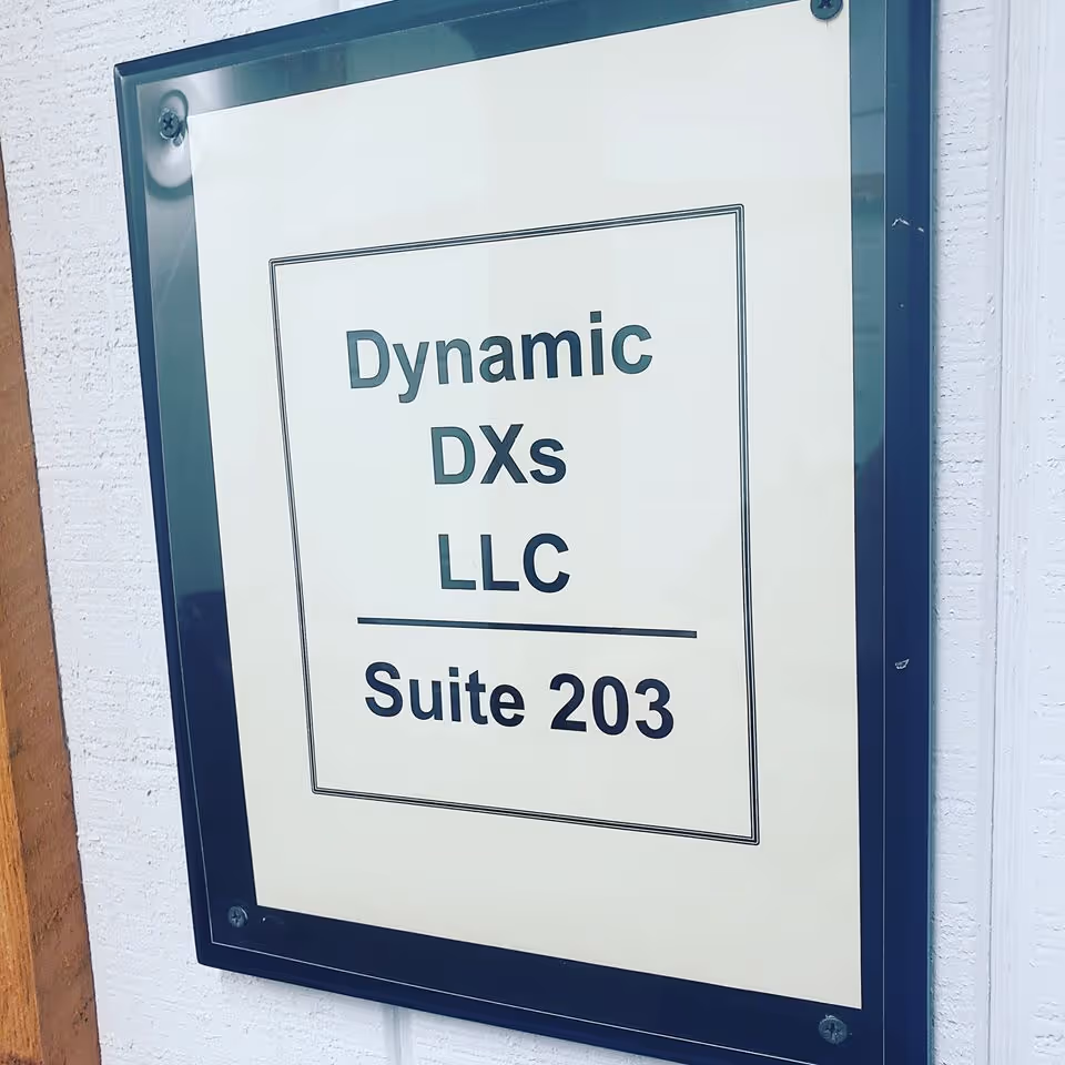 Exterior wall sign displays Dynamic DXs LLC and Suite 203.