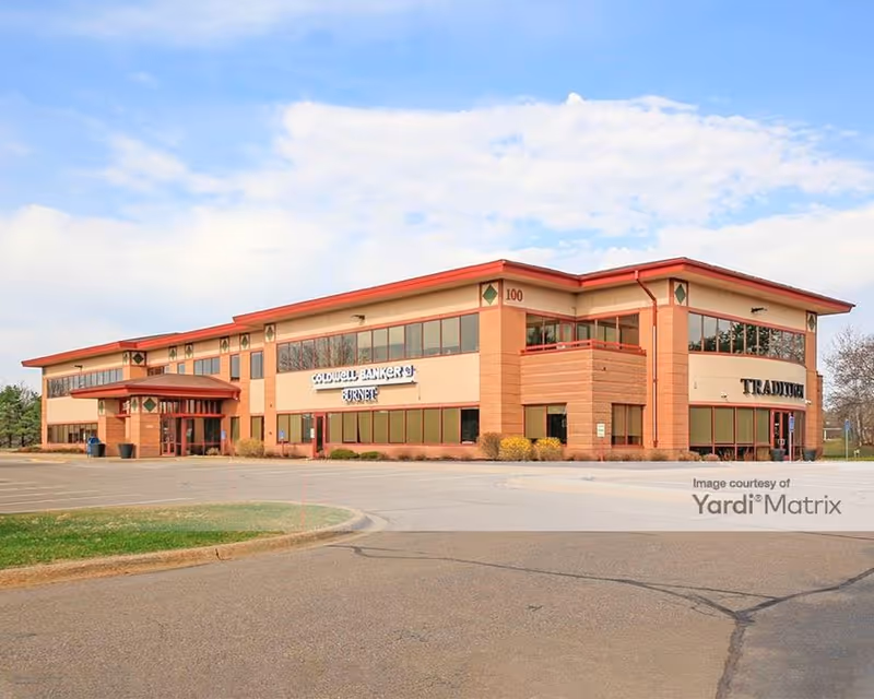 Two-story brick senior living facility with glass storefronts and a parking lot