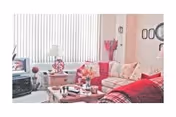 Cozy living room with red couch, coffee table, TV, and lamps.