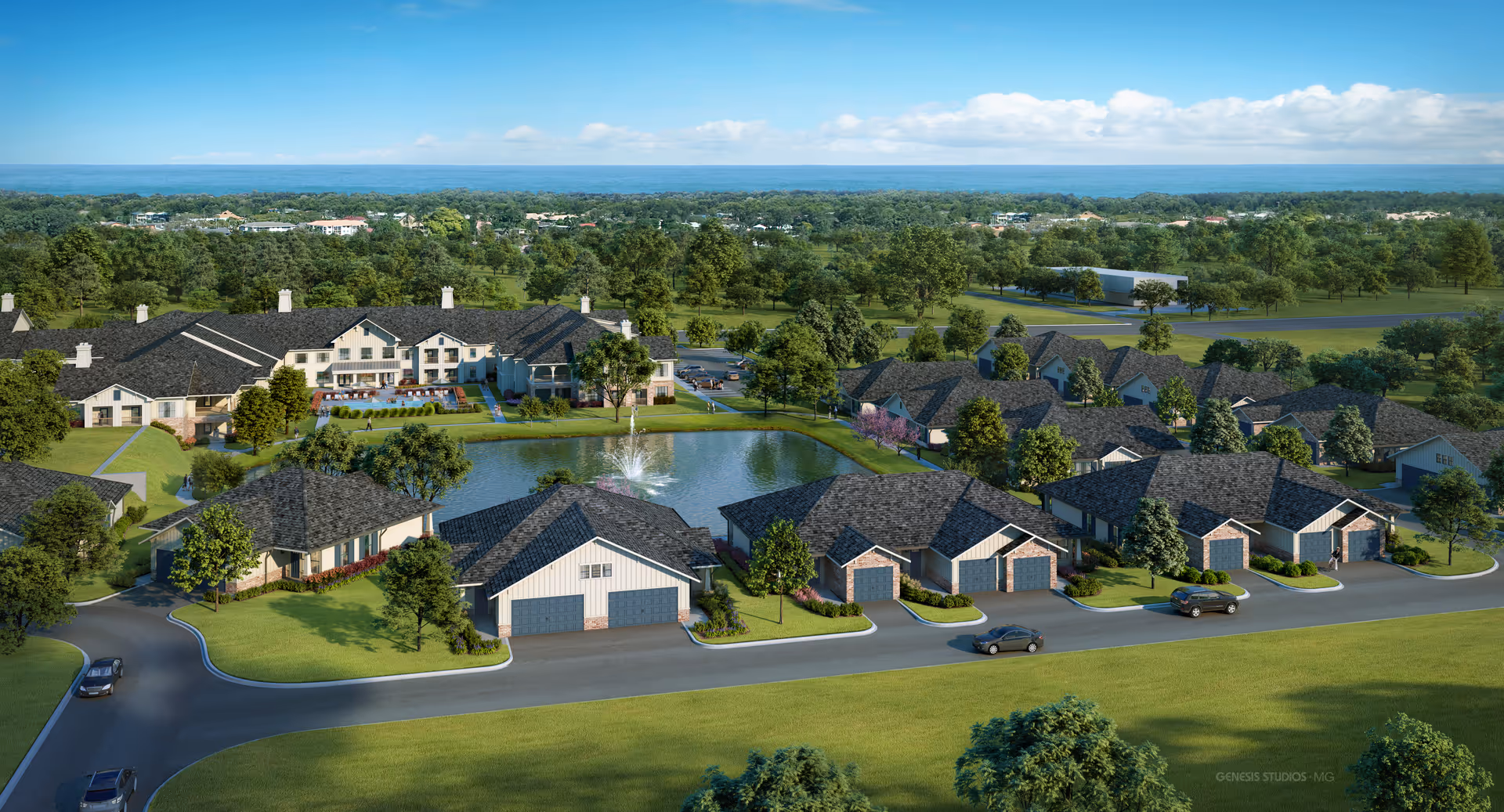Aerial view of Seagrass Village of Daphne senior living community featuring multiple residential buildings with dark roofs surrounding a central pond with a fountain, landscaped green lawns, trees, and a road with parked cars.