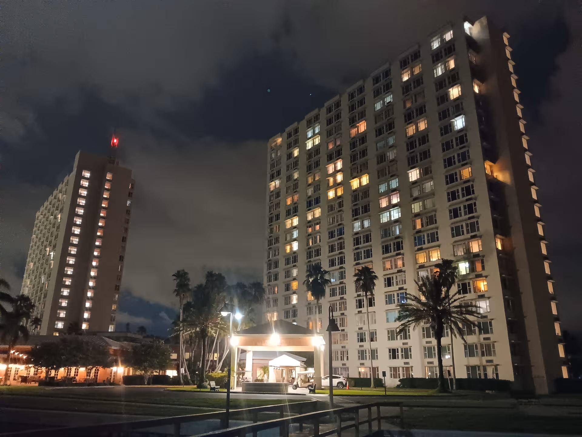 Nighttime view of The Barclay at Pasadena’s tall apartment buildings and illuminated entrance.