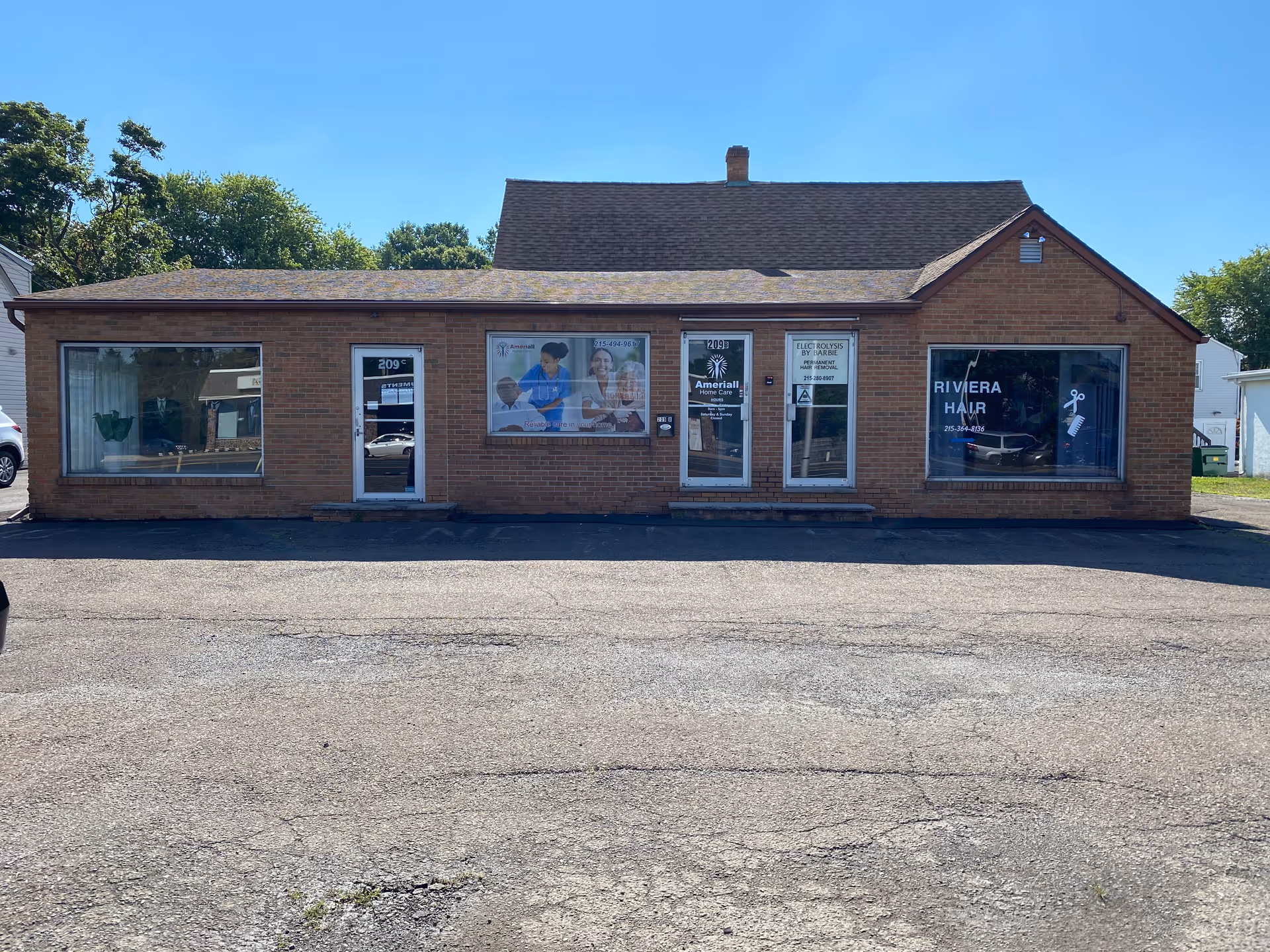 Single-story brick building with large storefront windows and a central entrance, labeled Ameriall Home Care.