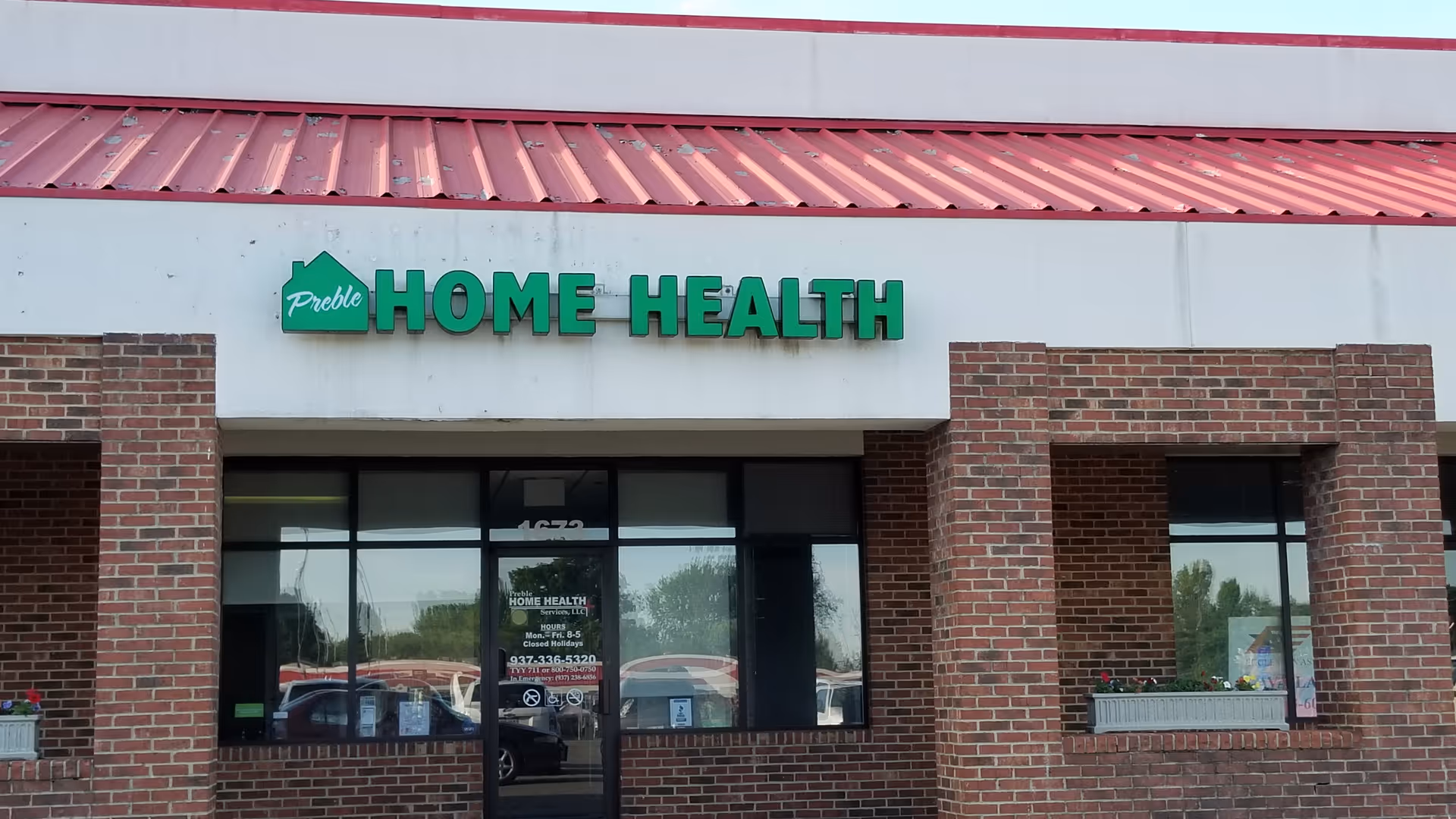 Brick storefront with a green HOME HEALTH sign and large front windows.