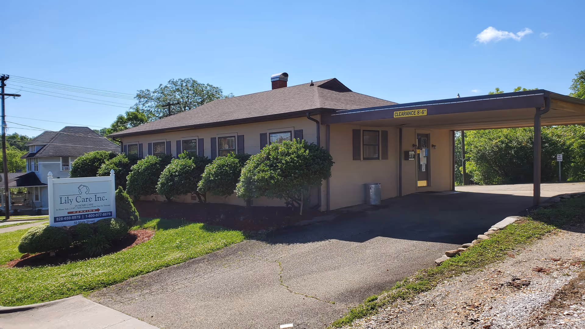 Single-story Lily Care facility front with manicured shrubs and a driveway.