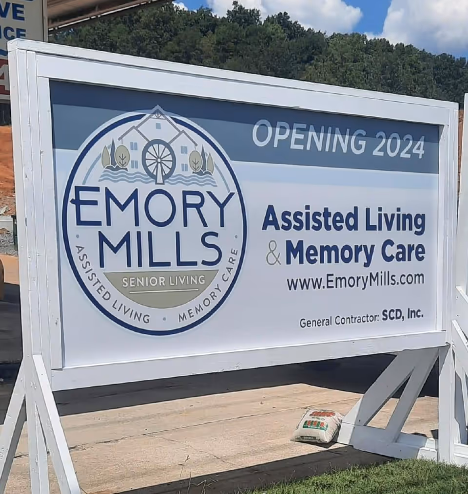 Outdoor construction sign advertising Emory Mills Senior Living opening in 2024