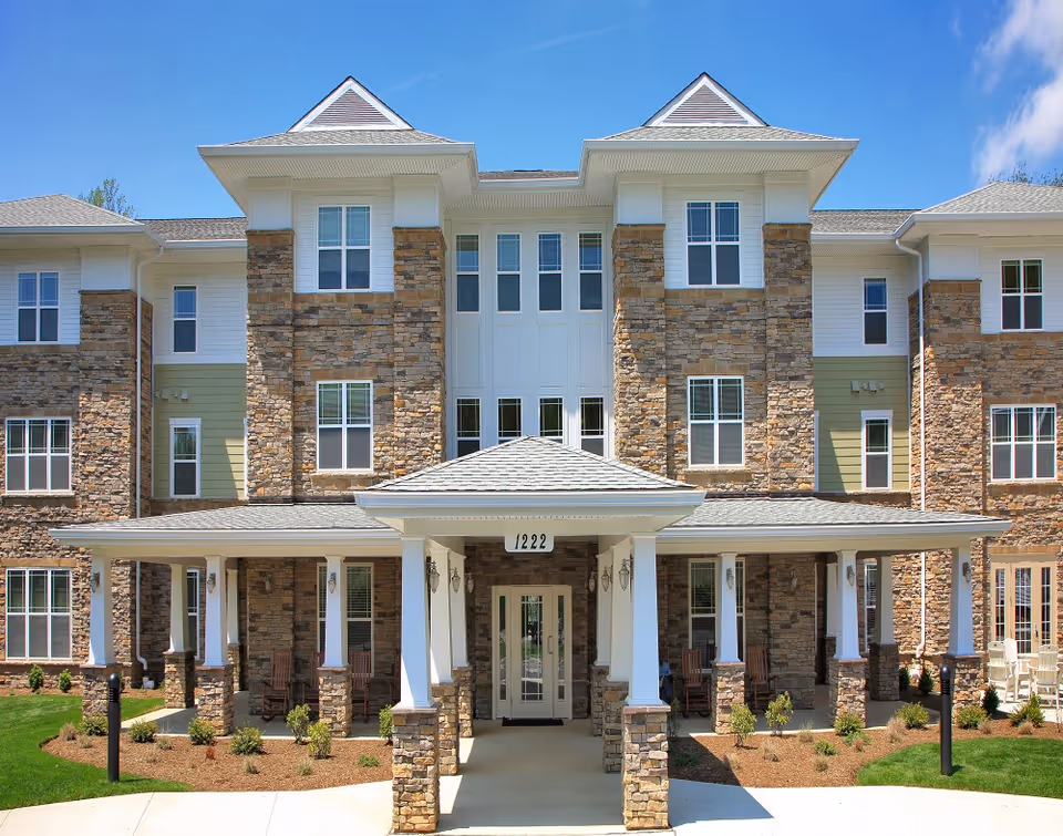 Front view of a Perryman Station senior living facility building with stone facade and entrance.