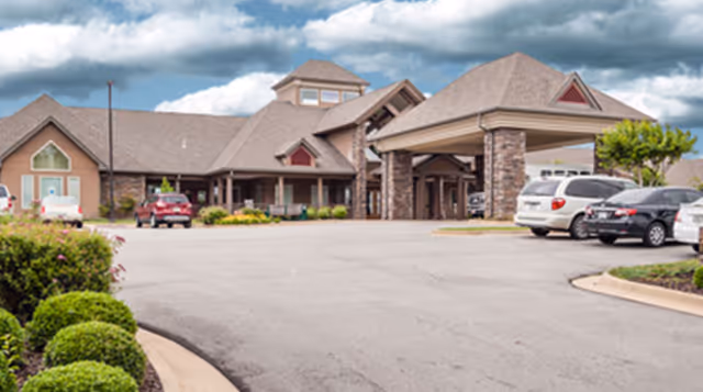 Exterior view of Lone Star Living facility with a front entrance and parked cars.