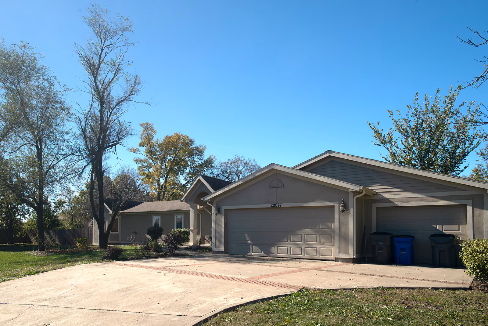 Exterior view of a senior living facility with a front-facing garage and driveway.