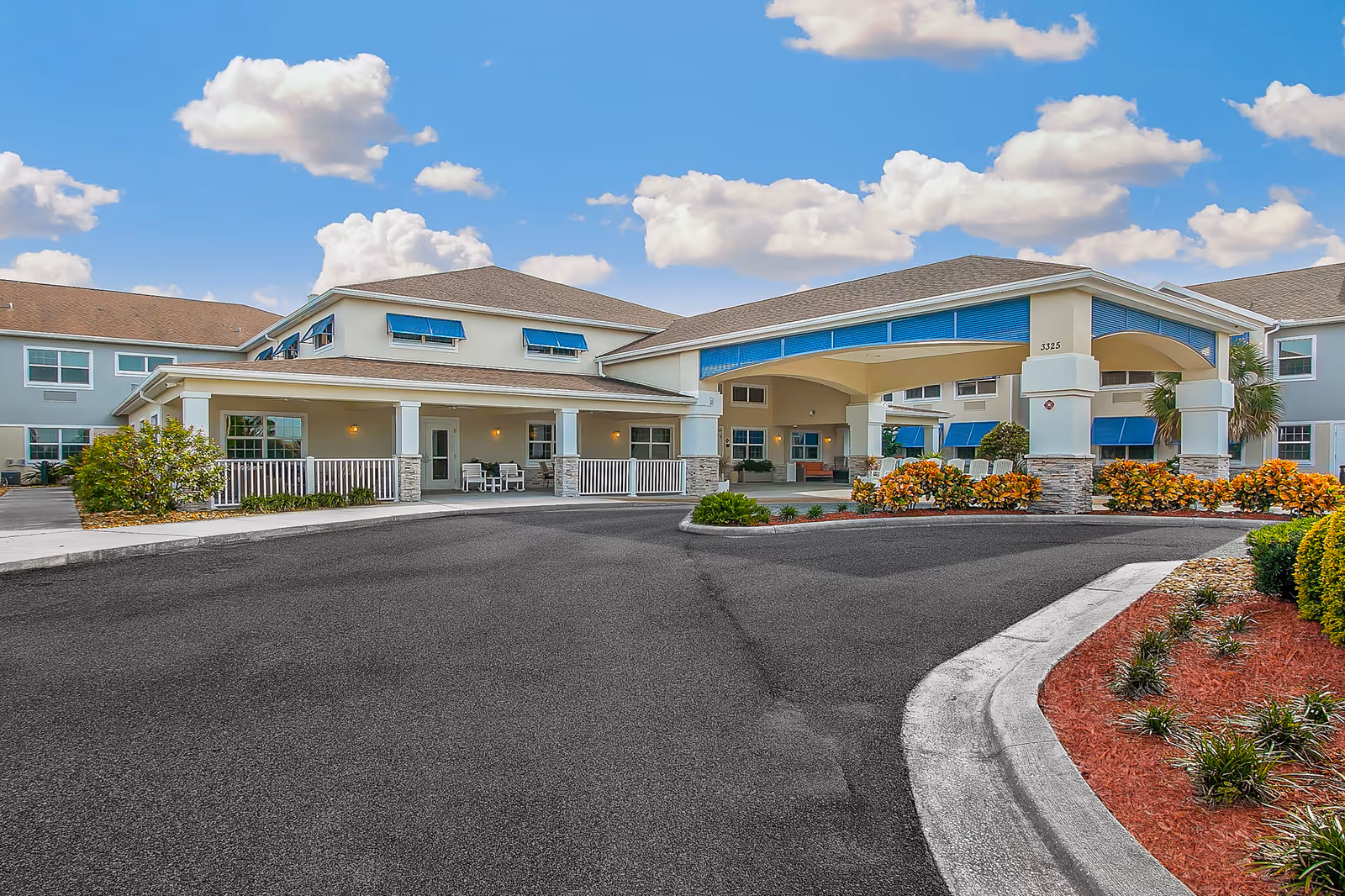 Sunny day exterior of Sonata Viera senior living facility with front entrance and landscaping