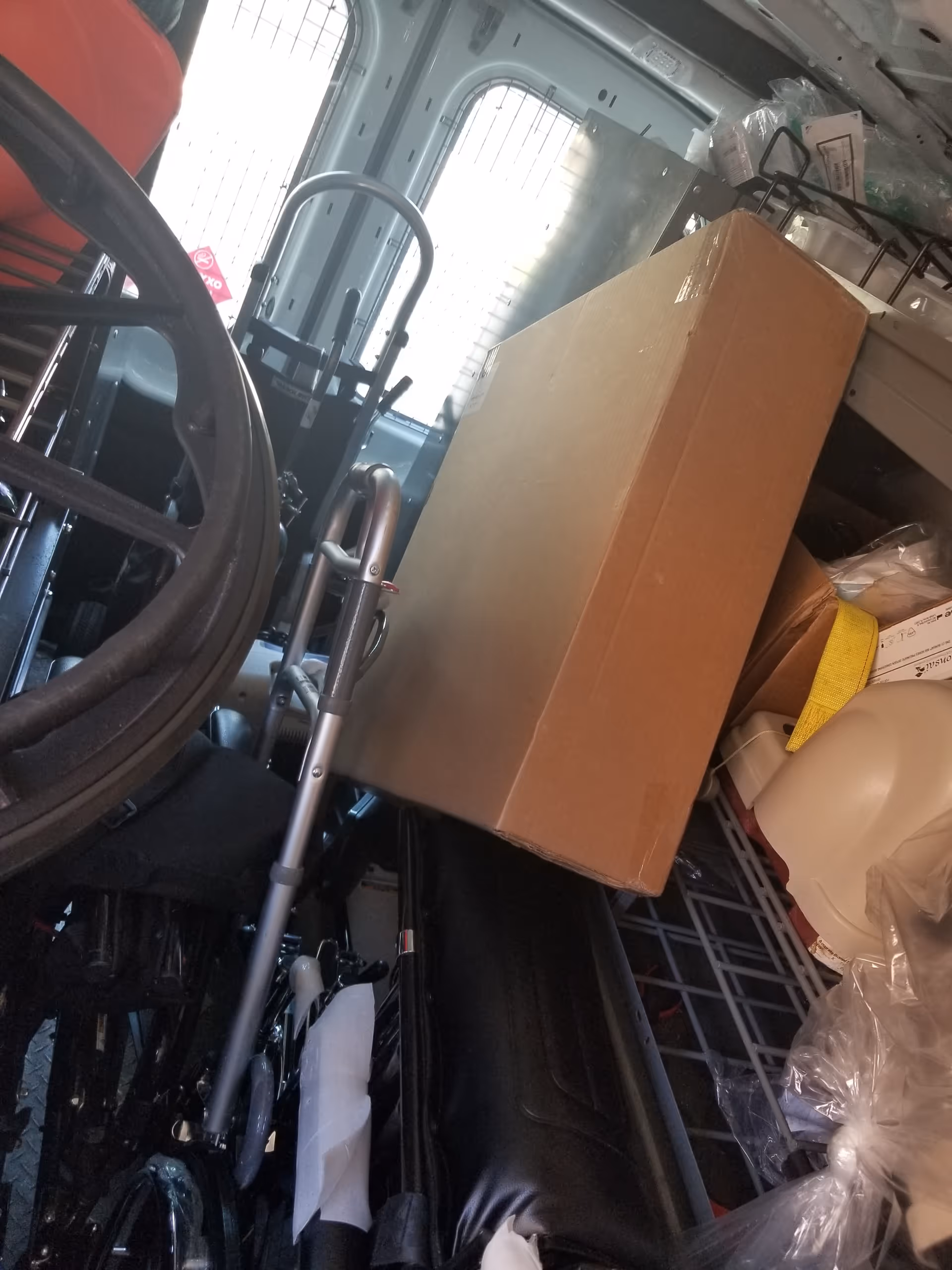Inside a vehicle's storage area with medical equipment and a cardboard box.