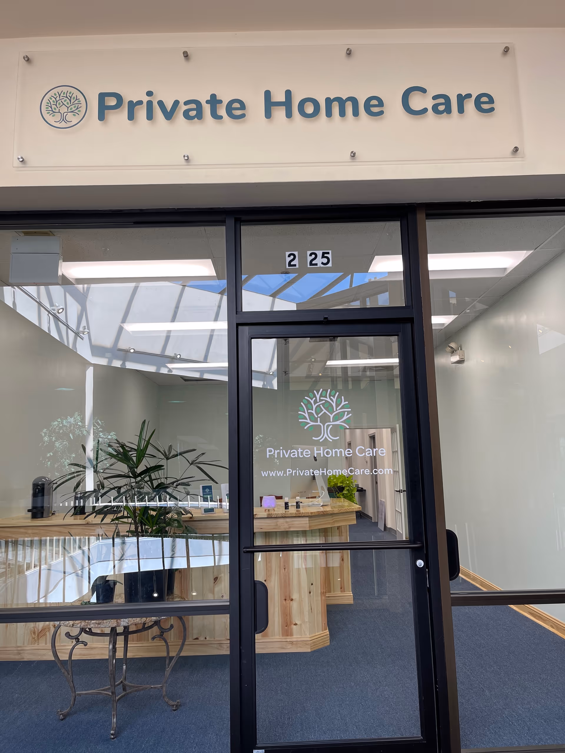 Reception area at Private Home Care with glass doors and a wooden desk