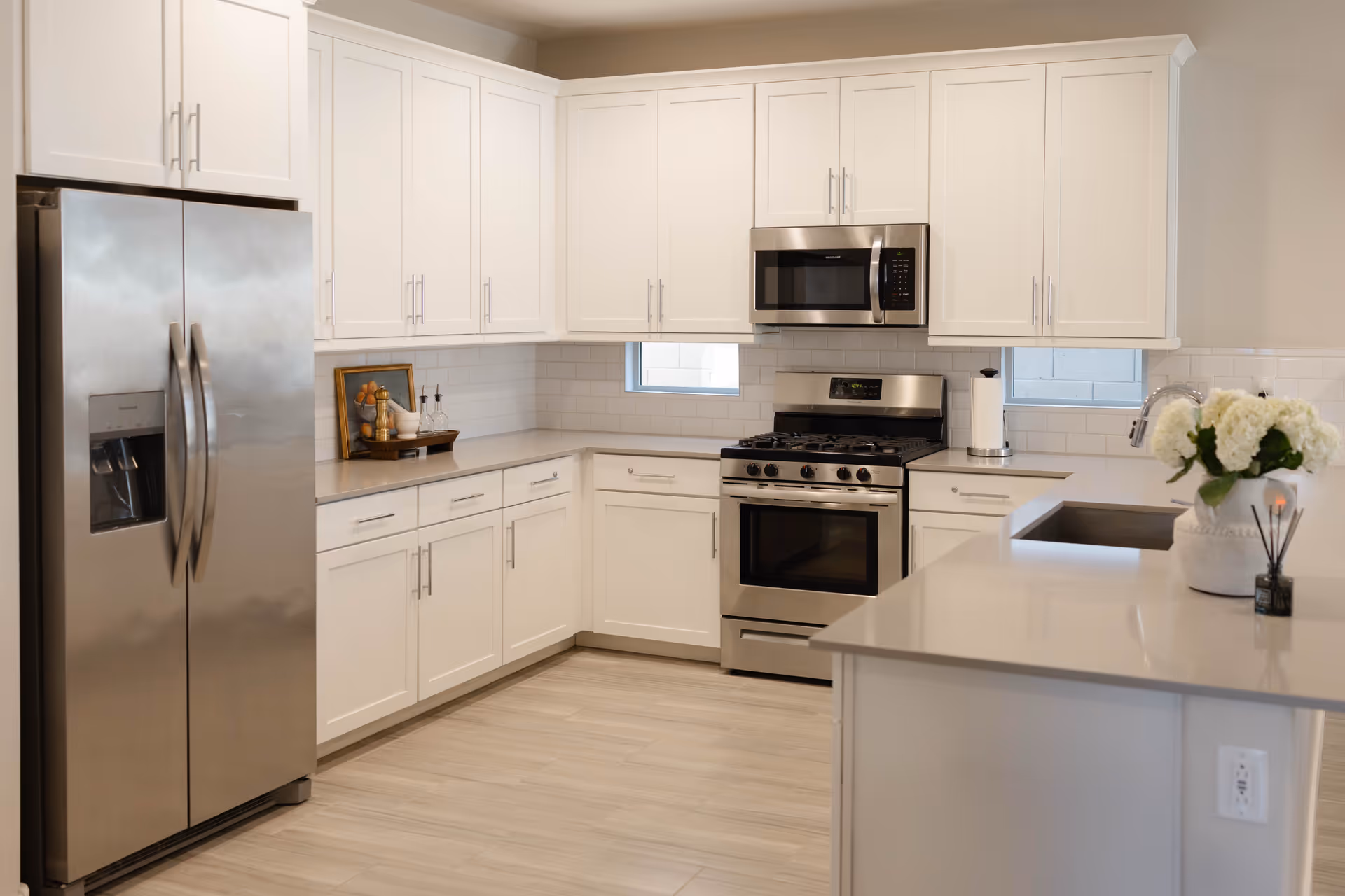 Bright white kitchen with stainless steel appliances and an island.