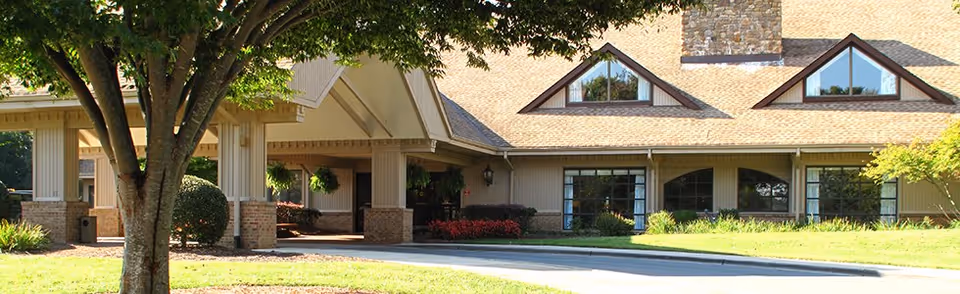The Bermuda Village Retirement Center exterior with a covered entrance and landscaped lawn.