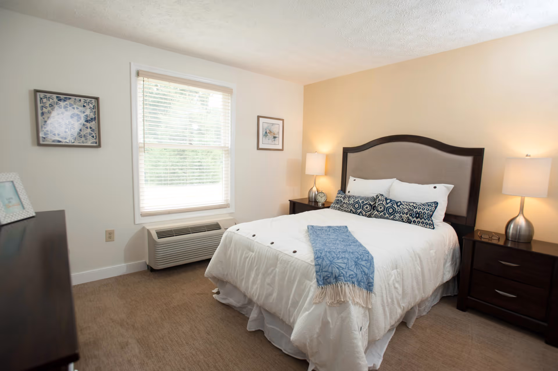 Bedroom at Forest Hill Heights senior living facility with a bed, nightstands, and lamps.