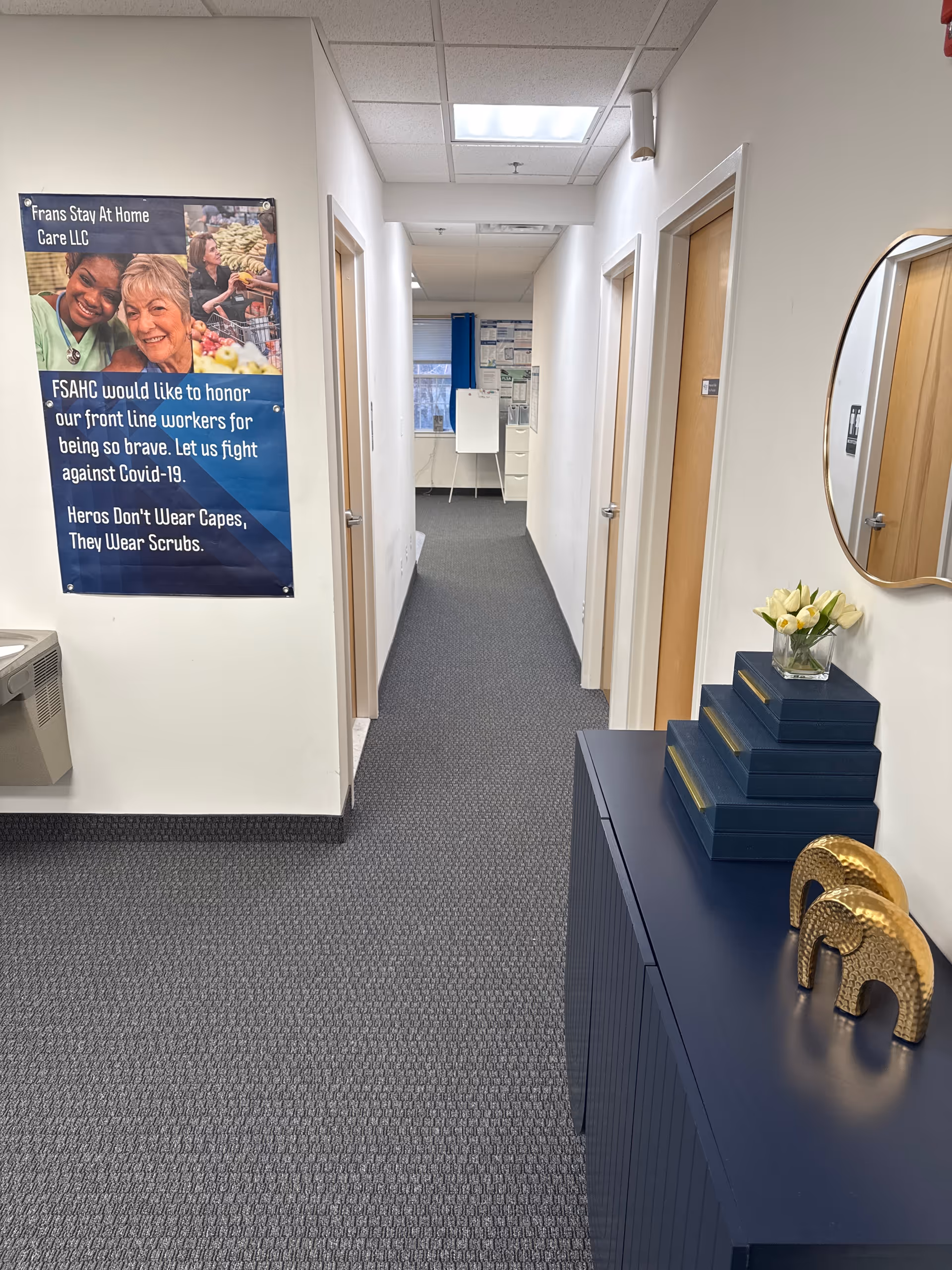 Indoor hallway of Frans Stay At Home Care LLC with blue console and wall poster