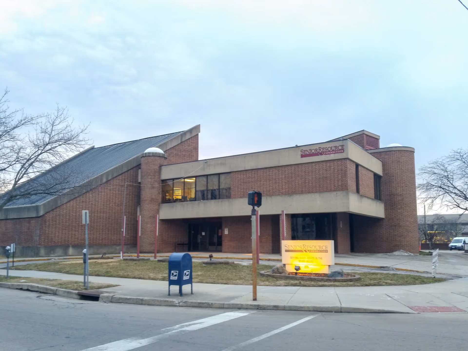 Brick senior resource center with curved entrance and illuminated Senior Resource Connection sign.