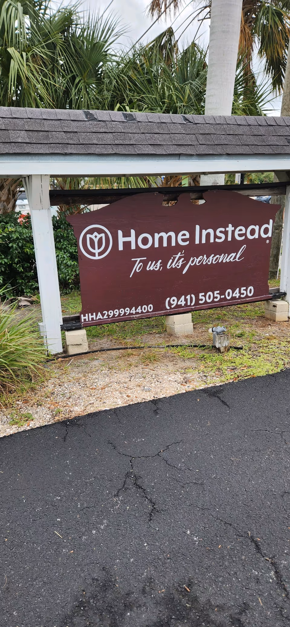 Maroon sign reads Home Instead and contact information in front of the facility.