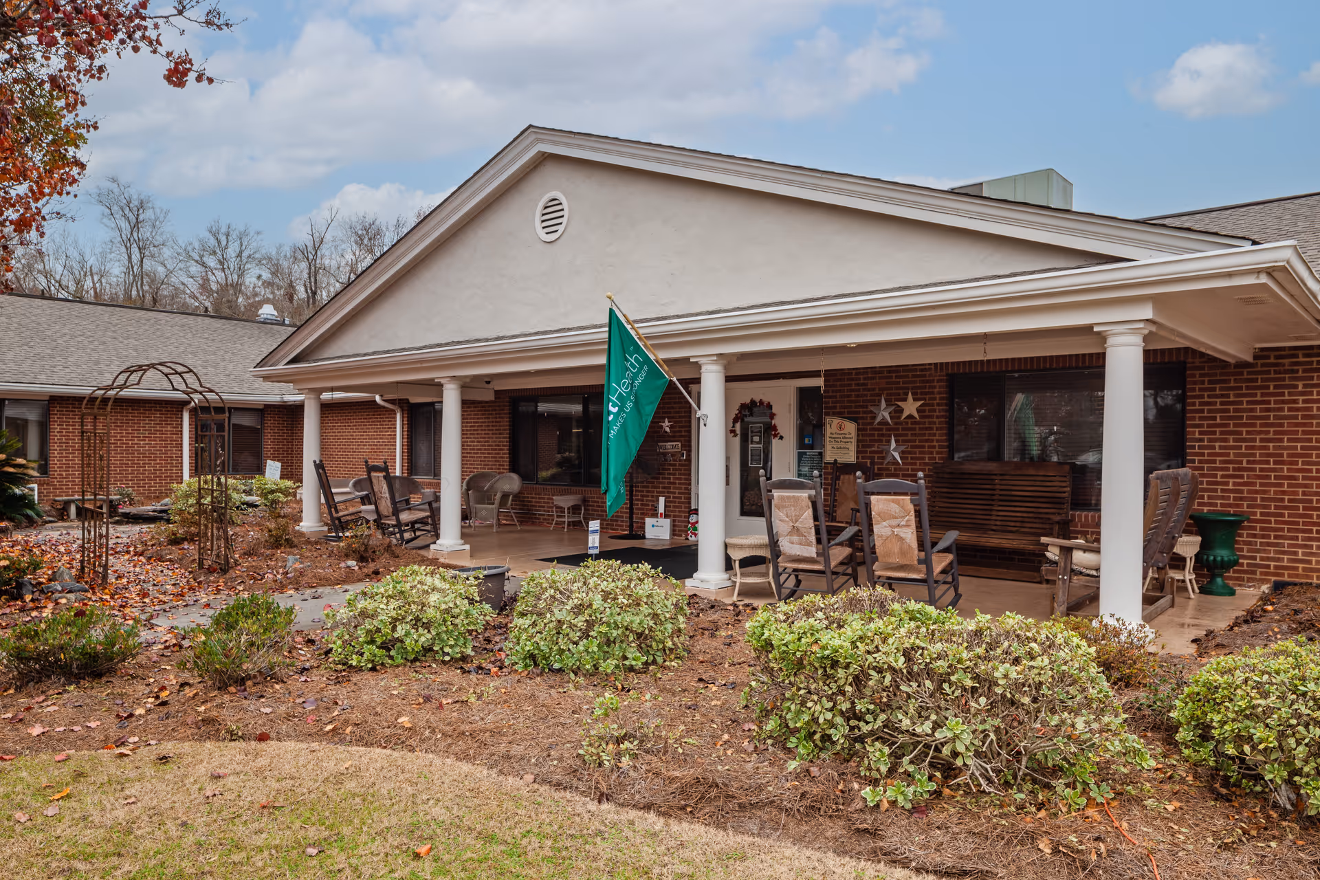 Exterior view of a Pruitthealth Toomsboro facility with a covered porch and outdoor seating.