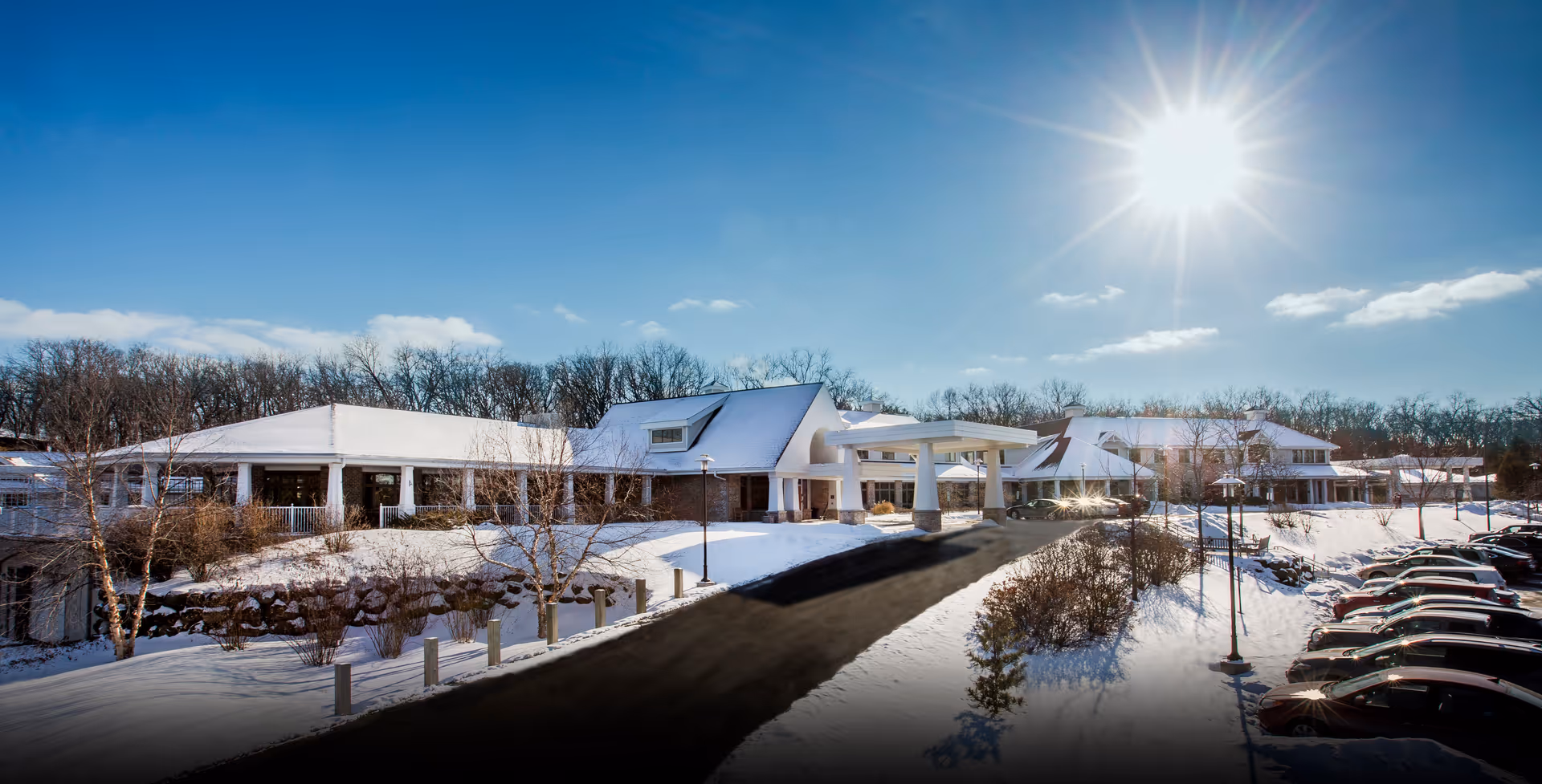 Agrace senior living facility exterior on a sunny snowy day with an entrance canopy.