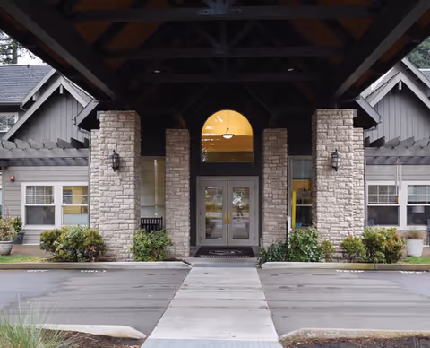 Entrance to Oswego Place by Bonaventure, a stone-front building with glass doors.