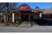Front entrance of Grace Healthcare of Cordova with maroon awning and walkway.