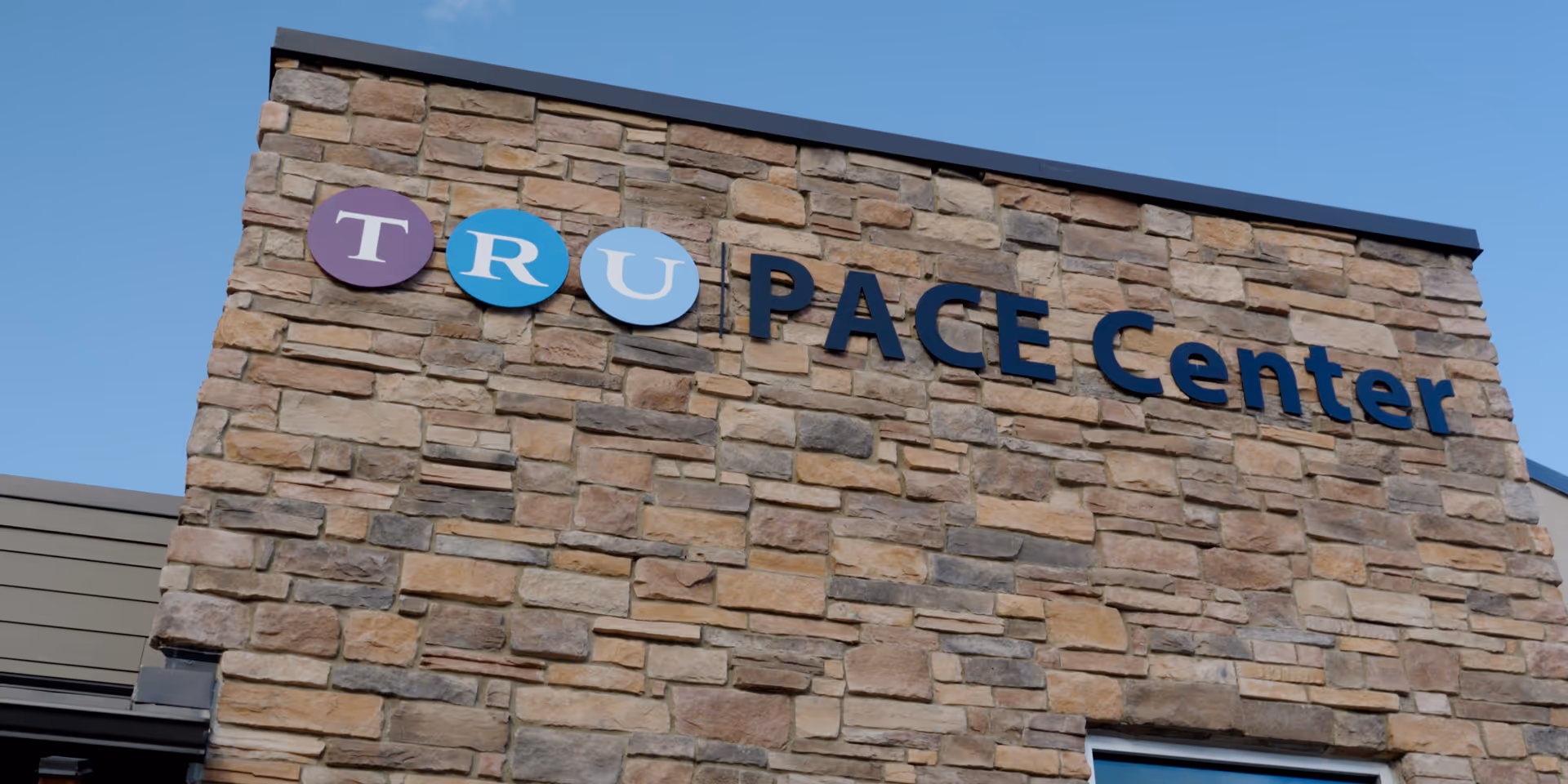 Stone facade with a TRU PACE Center sign on the building front.