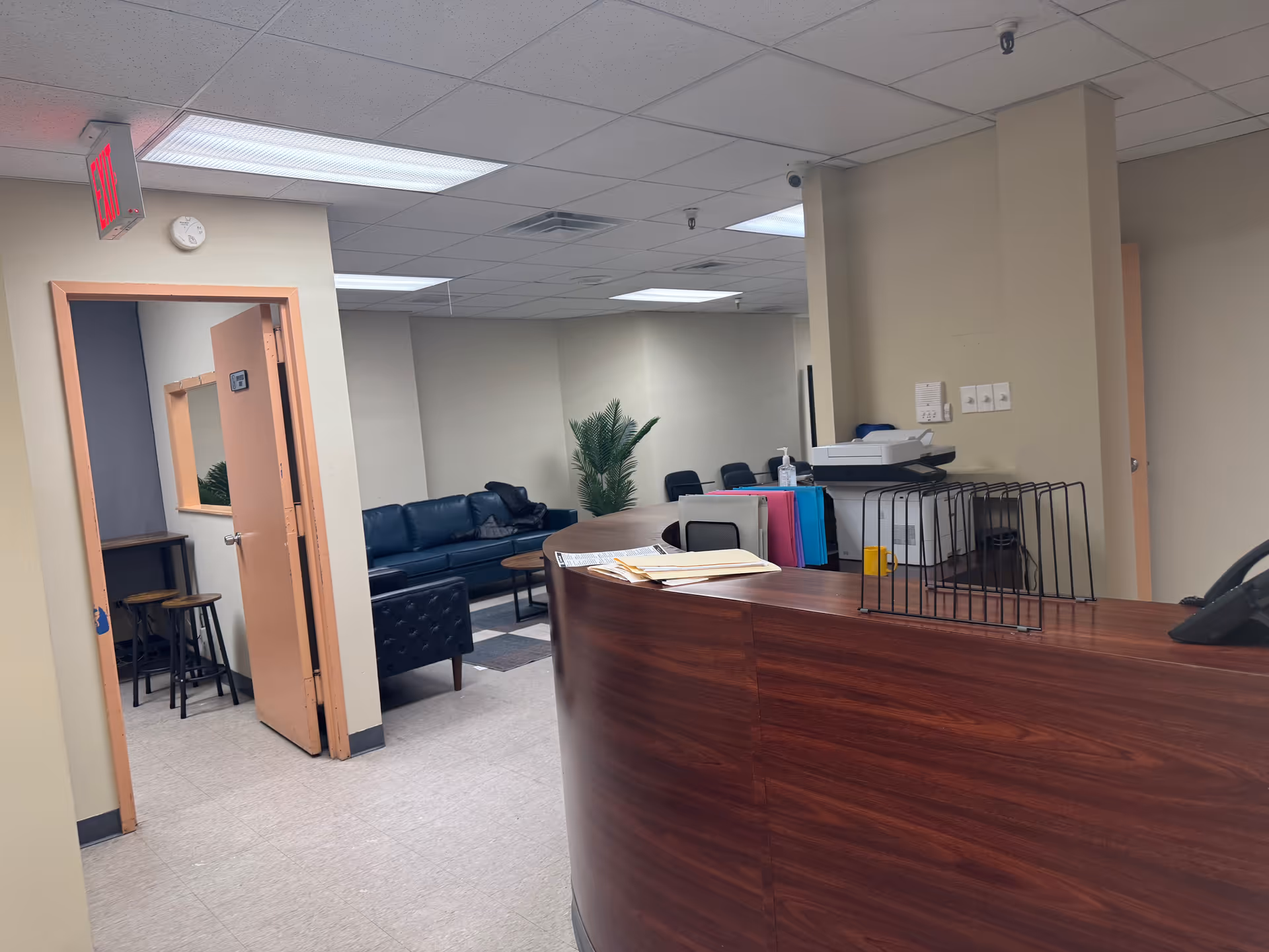 Reception desk in a senior living facility lobby with seating area.