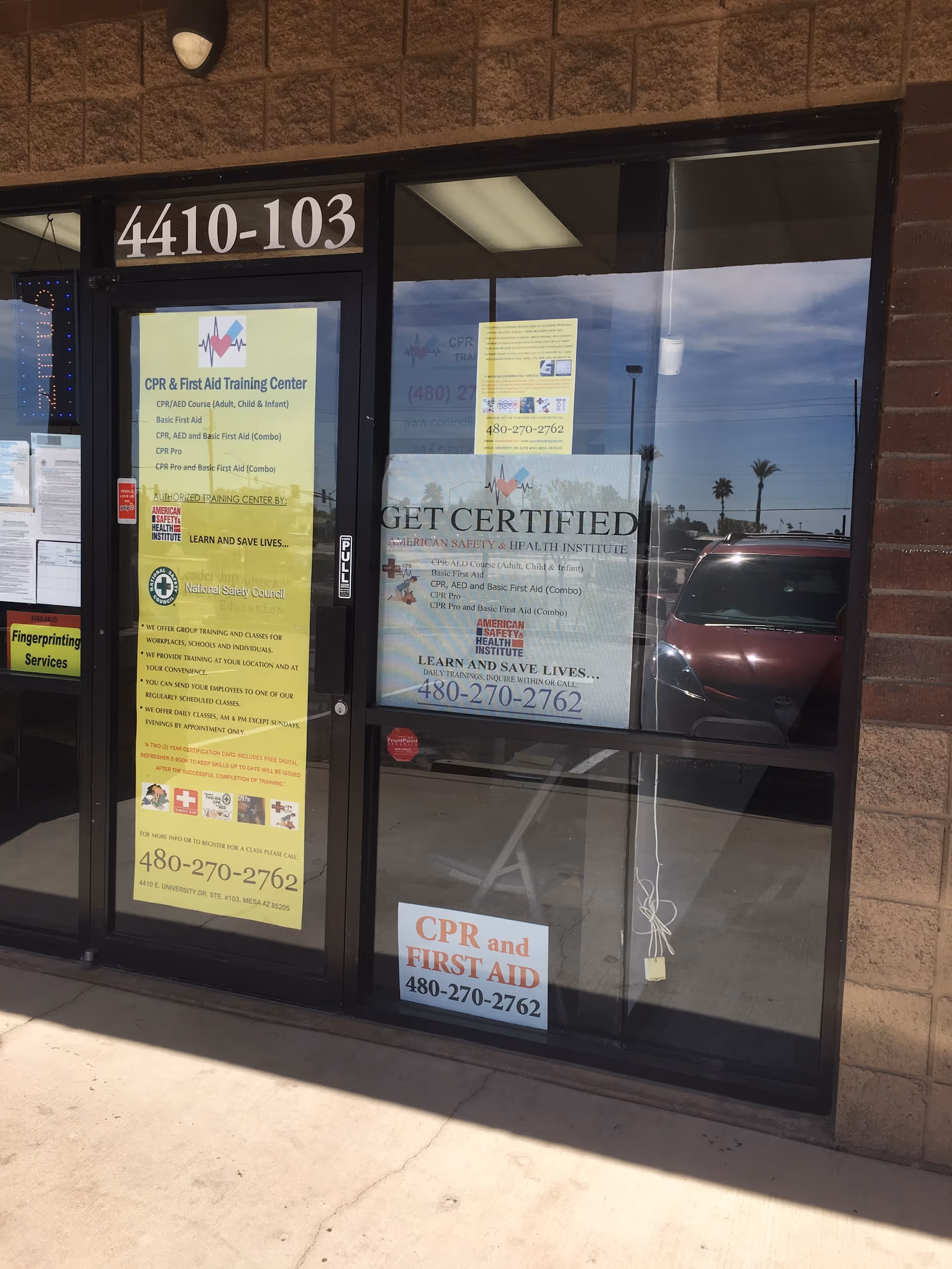 Storefront entrance with CPR and First Aid Training Center posters on glass doors.