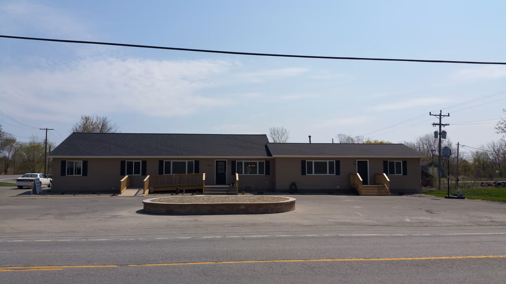 Single-story care facility facade with several entrances and a circular driveway.