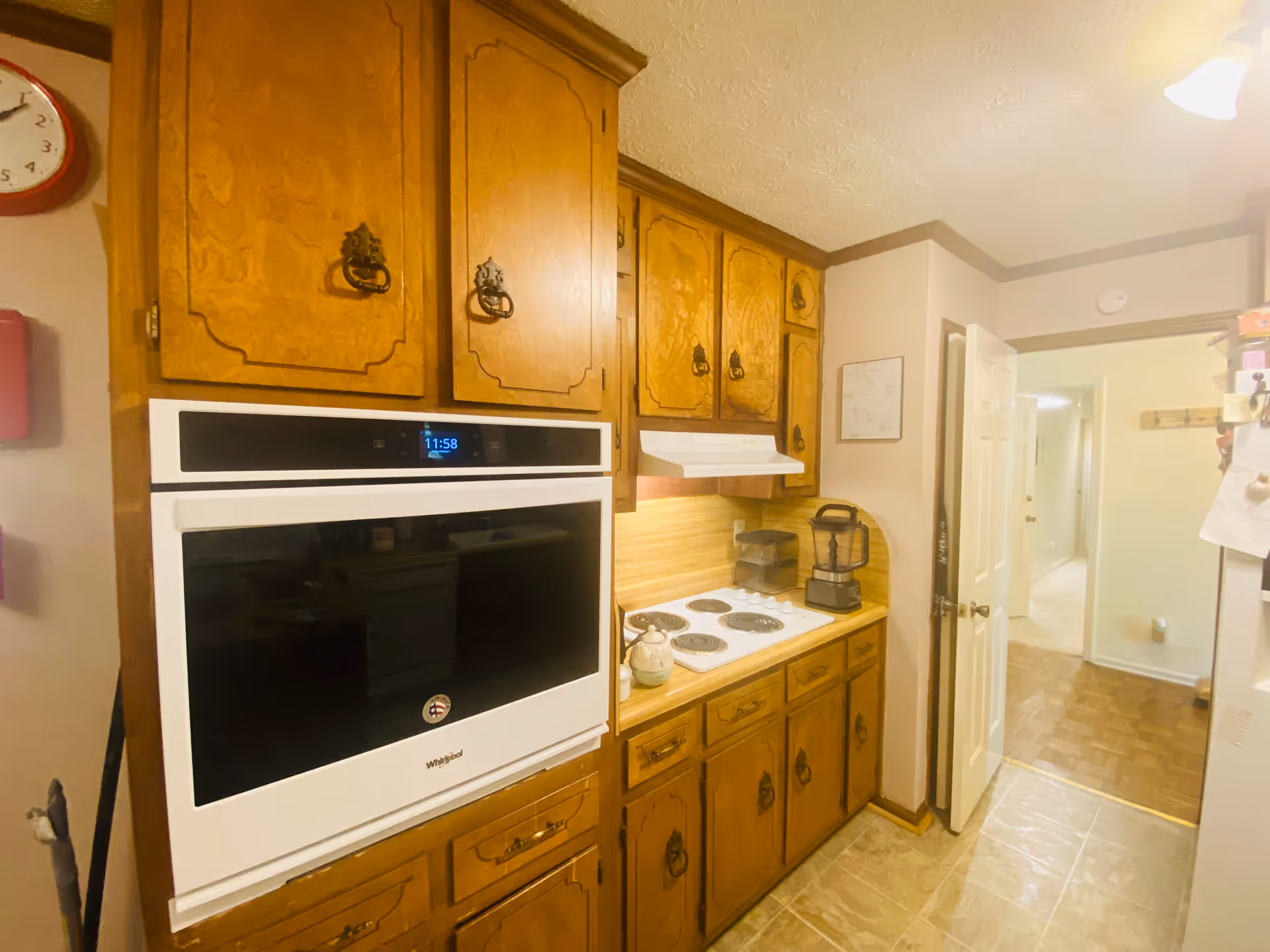 Wooden cabinets surround a white built-in oven and stove in a compact residential kitchen.
