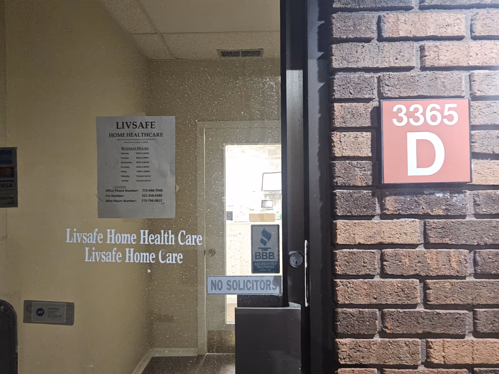 Entrance of LivSafe Home Health Care on a brick building with glass door.
