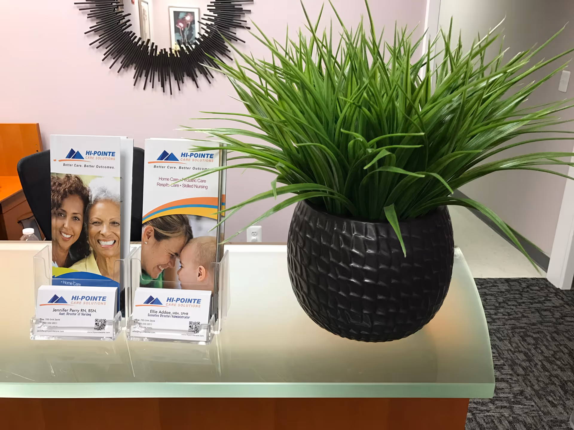 Reception desk featuring a large potted plant and Hi-Pointe brochures.