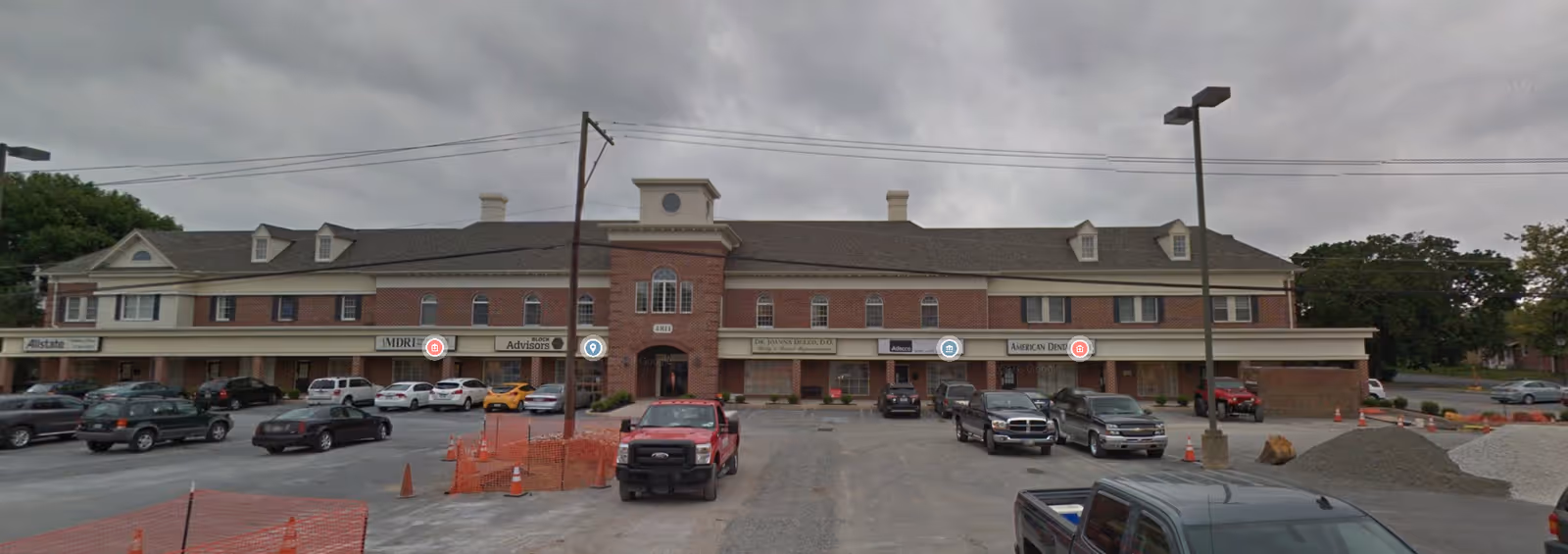Exterior view of Comfort Care LLC senior living facility with brick facade and parked cars.