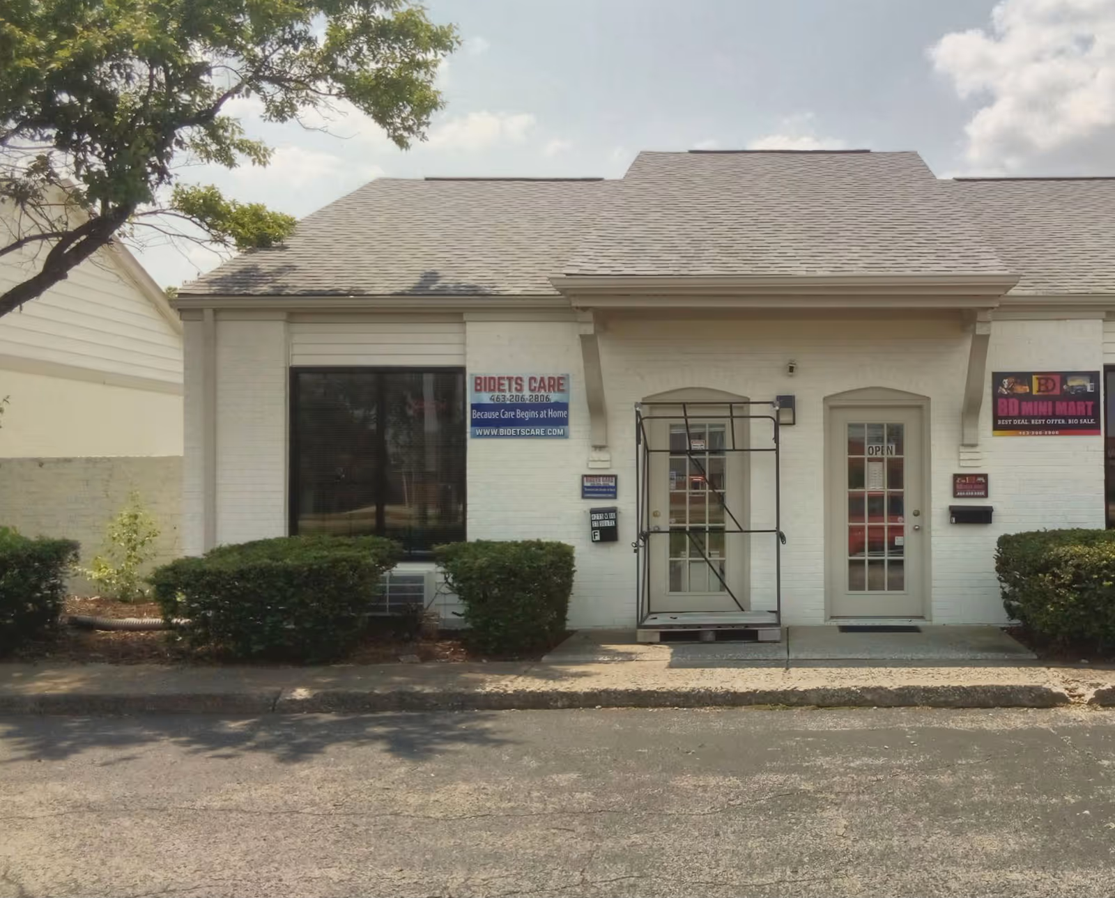 Front view of a white building with double doors and signs for Bidets Care LLC.