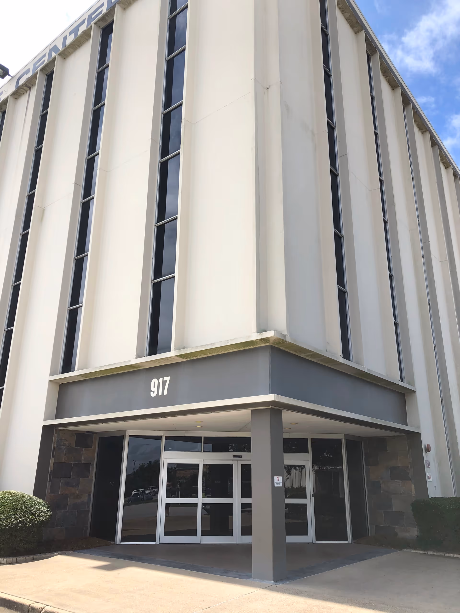 Exterior view of a modern senior living facility entrance with tall vertical windows.