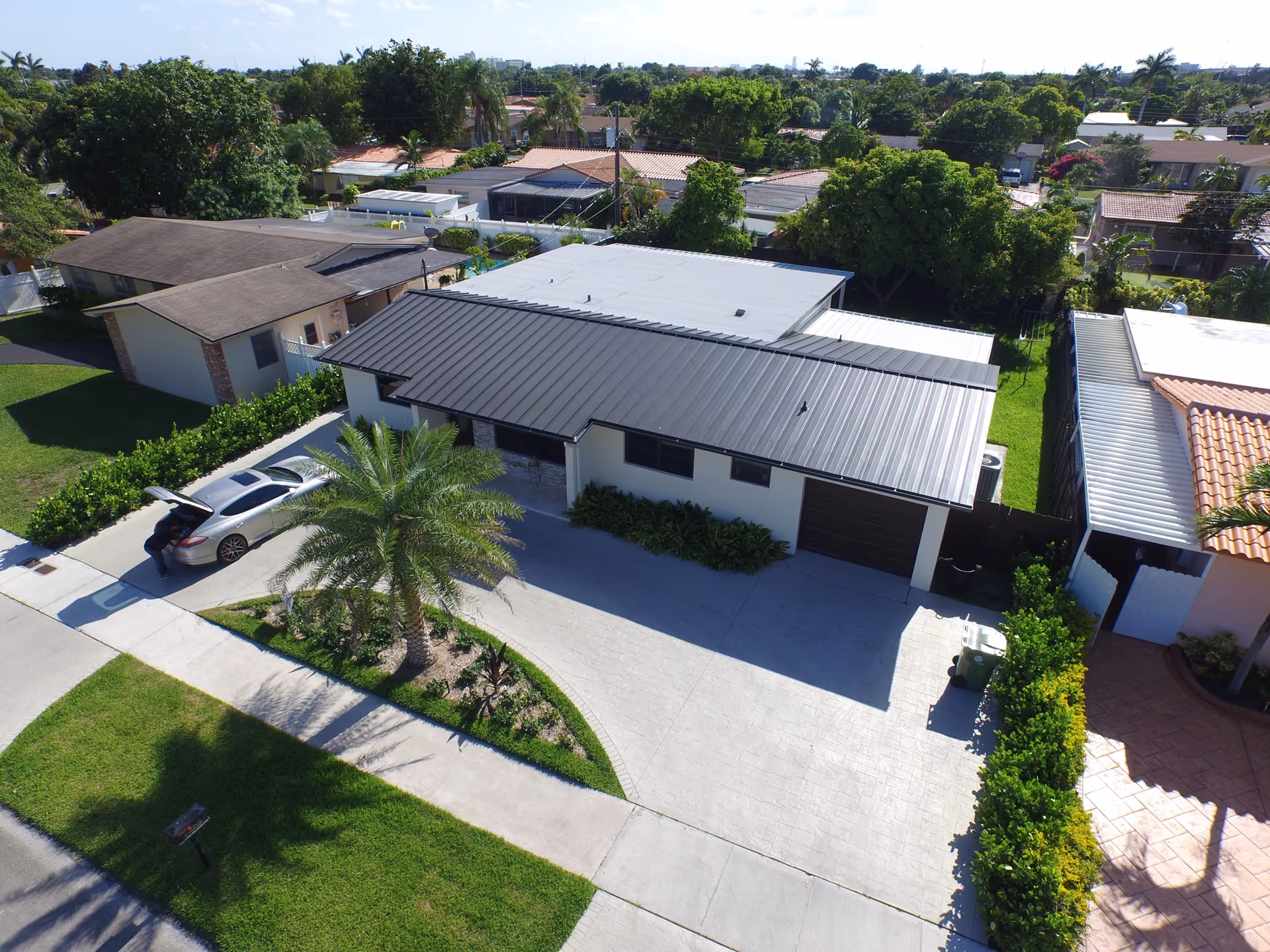 Aerial view of a single-story building with driveway and landscaped front yard.