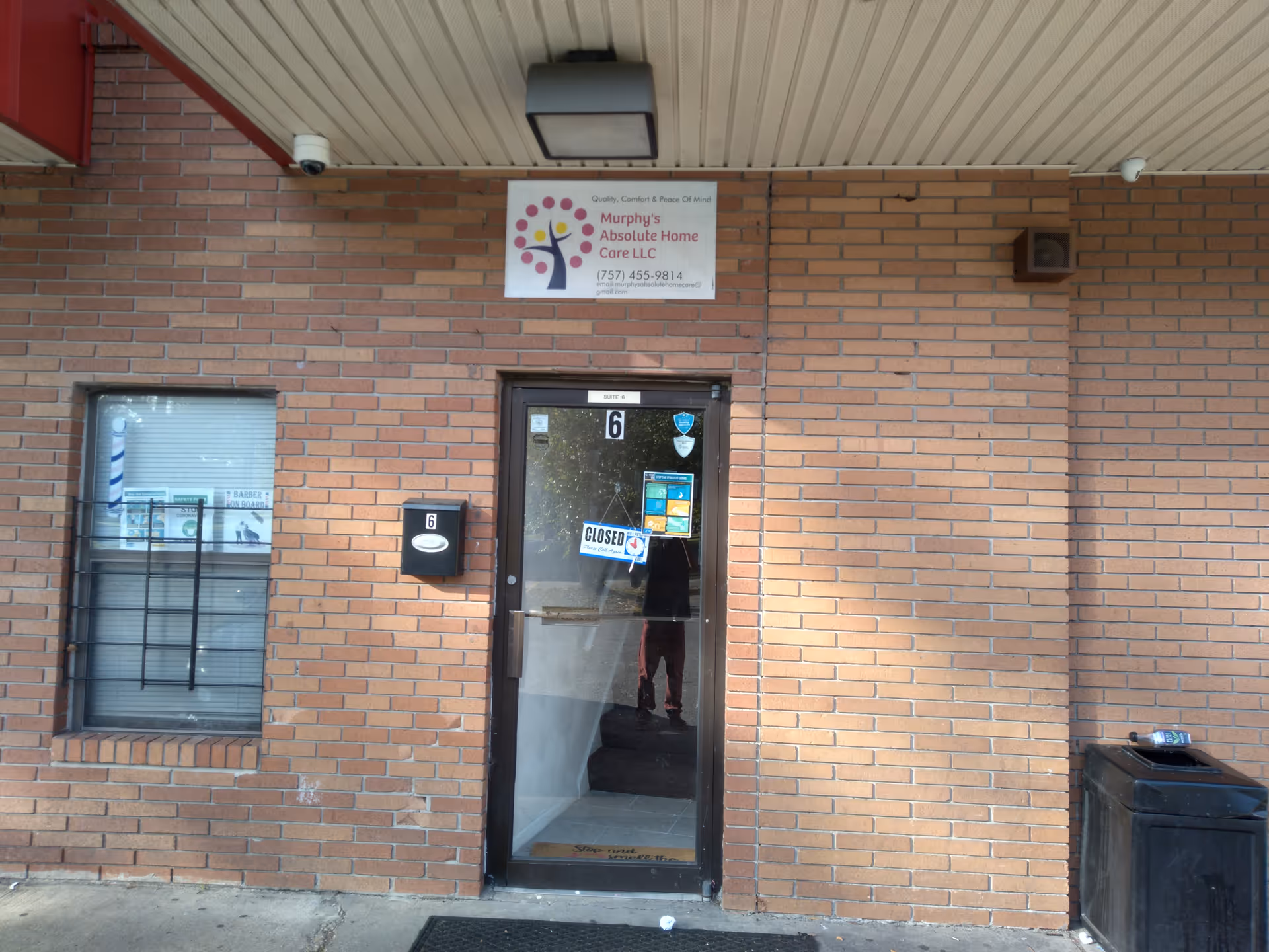 Brick building exterior with Murphy's Absolute Home Care LLC sign above a glass door.
