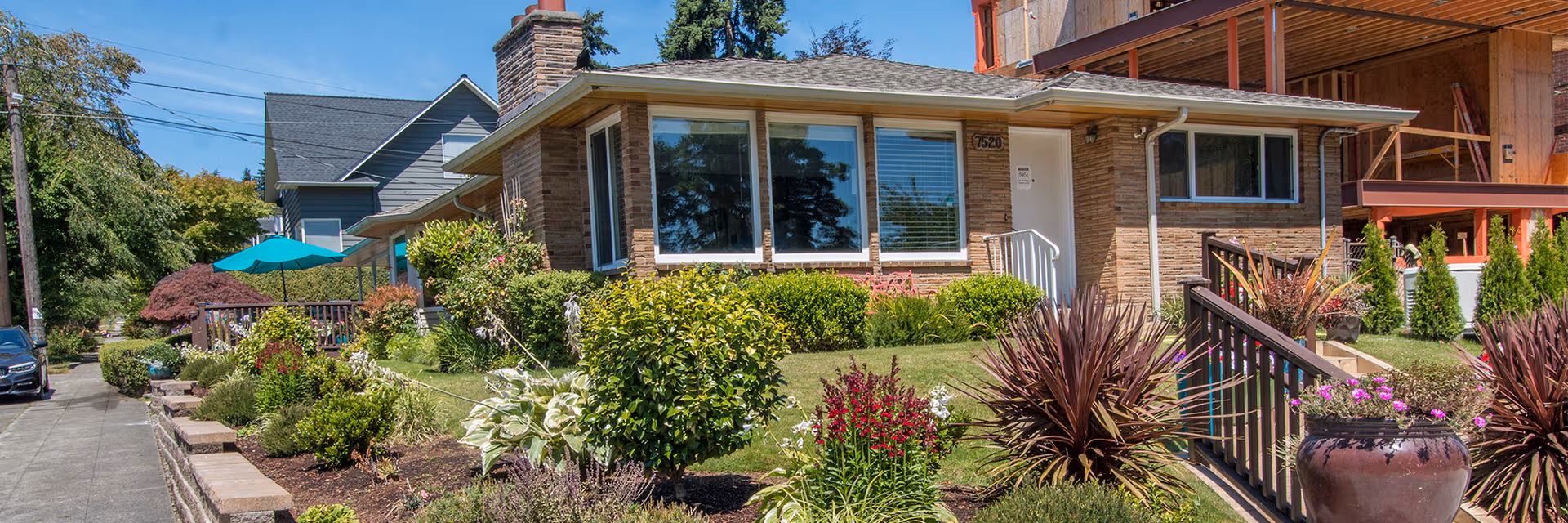 Single-story brick senior living home with landscaped front yard, railing, and outdoor seating.