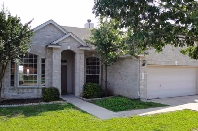 Front exterior of Clare Creek Personal Care Home, brick building with arched entrance and driveway.