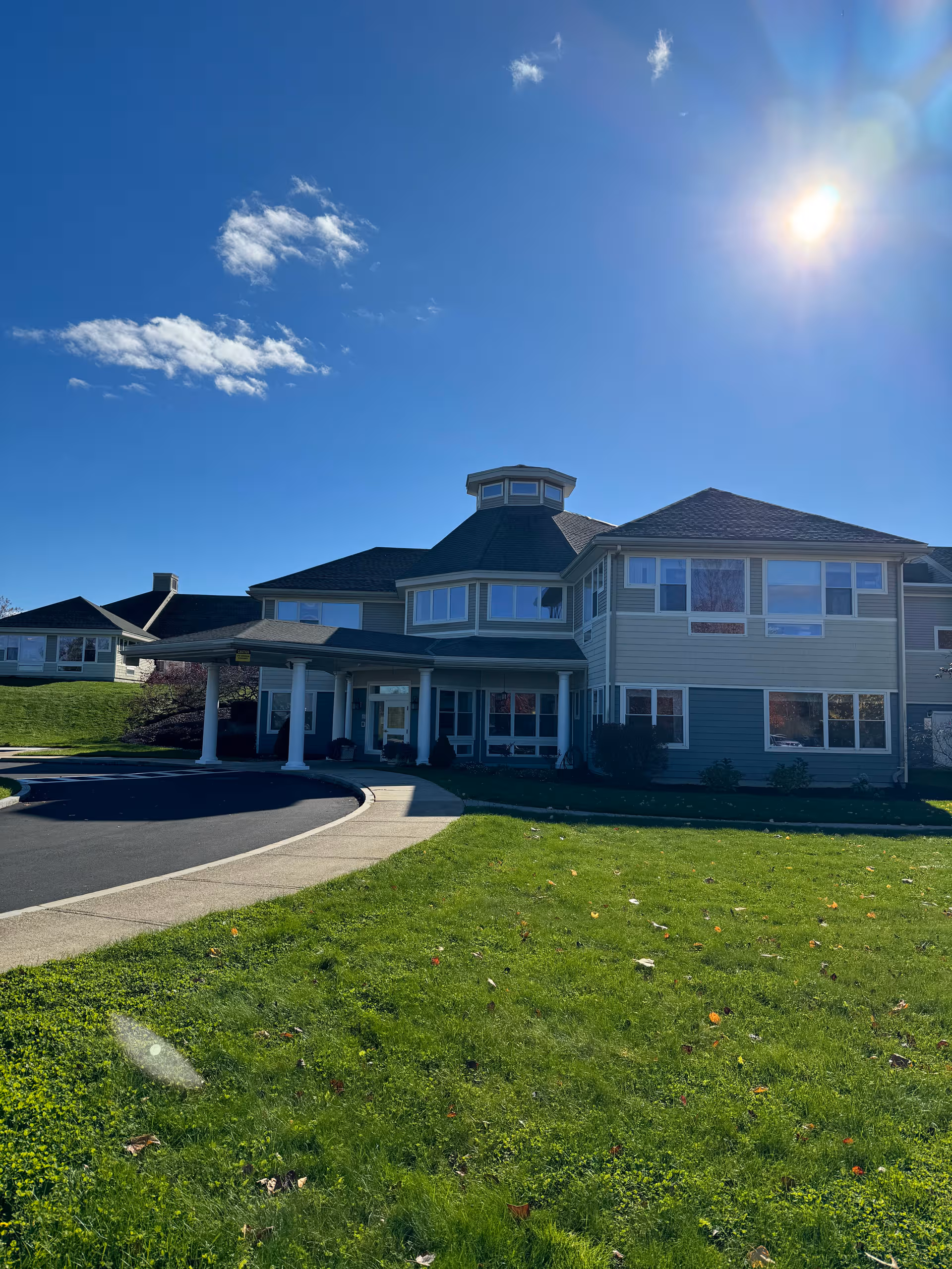 Exterior view of a multi-story senior living facility with a covered entrance and driveway.