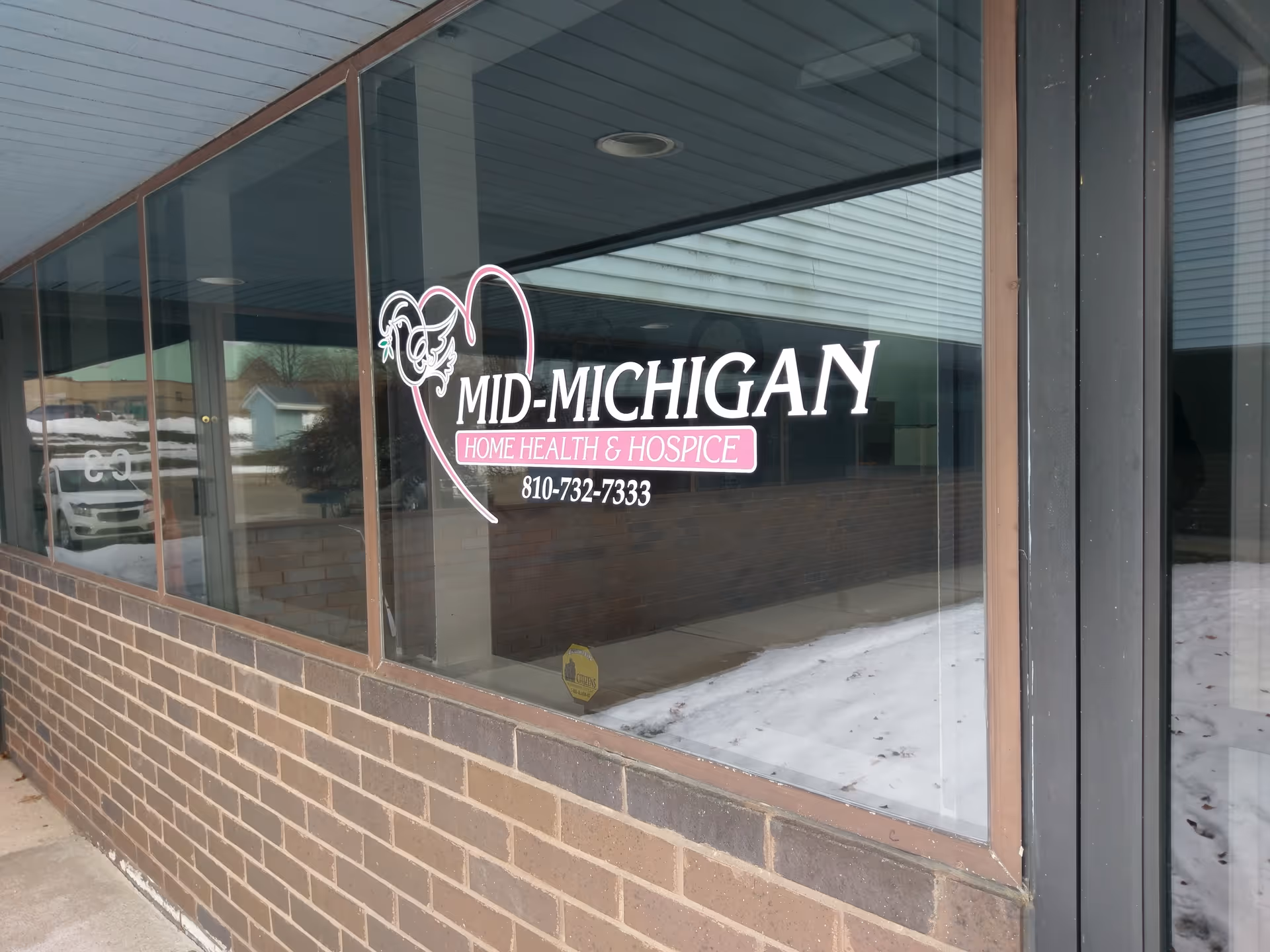 Exterior view of a Mid-Michigan Home Health and Hospice storefront with glass windows.