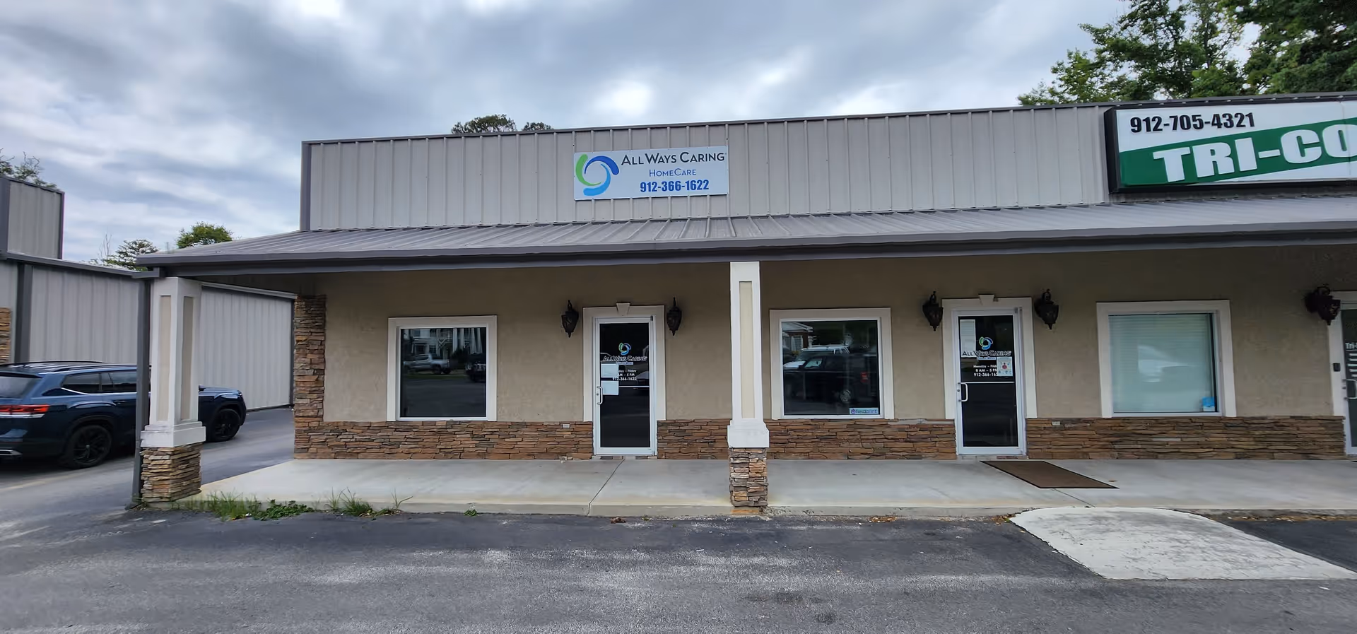 Single-story commercial storefront with three doors, stone accents, and All Ways Caring HomeCare Baxley signage.
