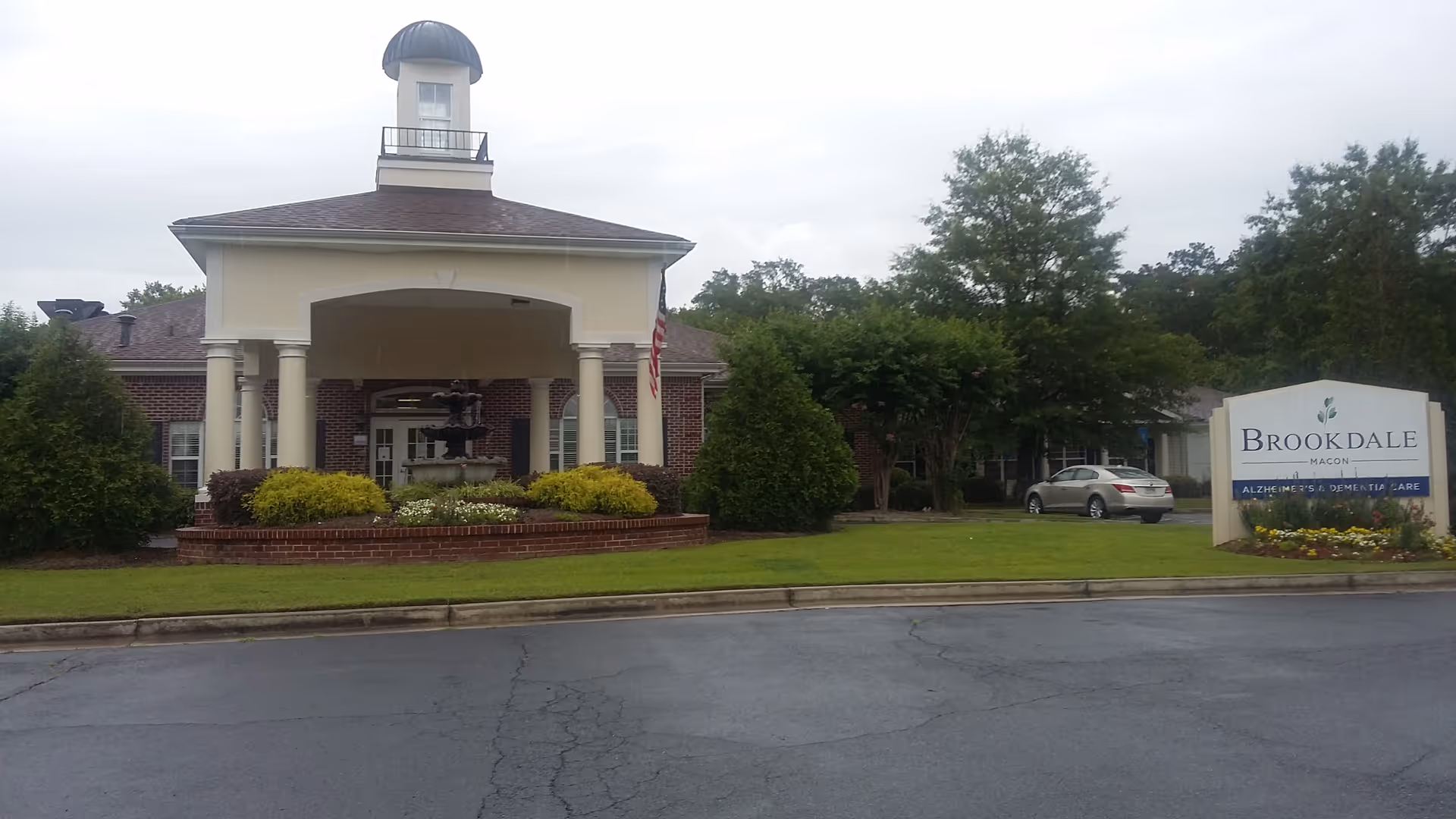 Outside view of a senior living facility with a covered entrance and landscaping.